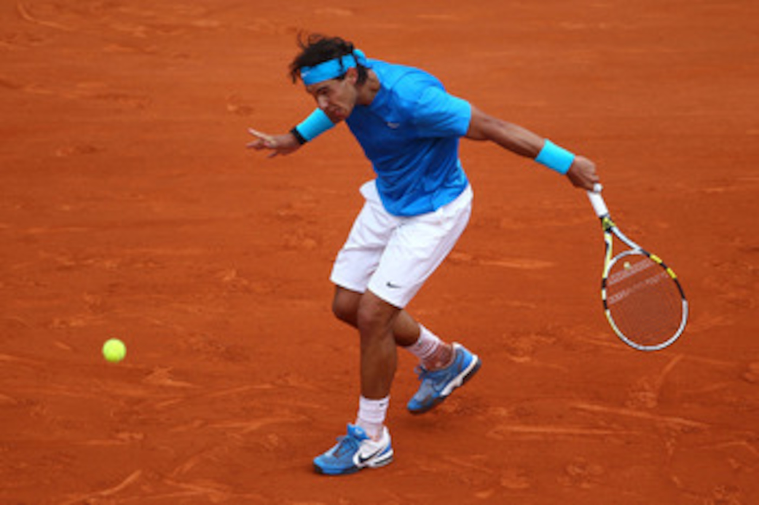 PARIS, FRANCE - MAY 30:  Rafael Nadal of Spain hits a backhand during the men's singles round four match between Rafael Nadal of Spain and Ivan Lubicic of Croatia on day nine of the French Open at Roland Garros on May 30, 2011 in Paris, France.  (Photo by