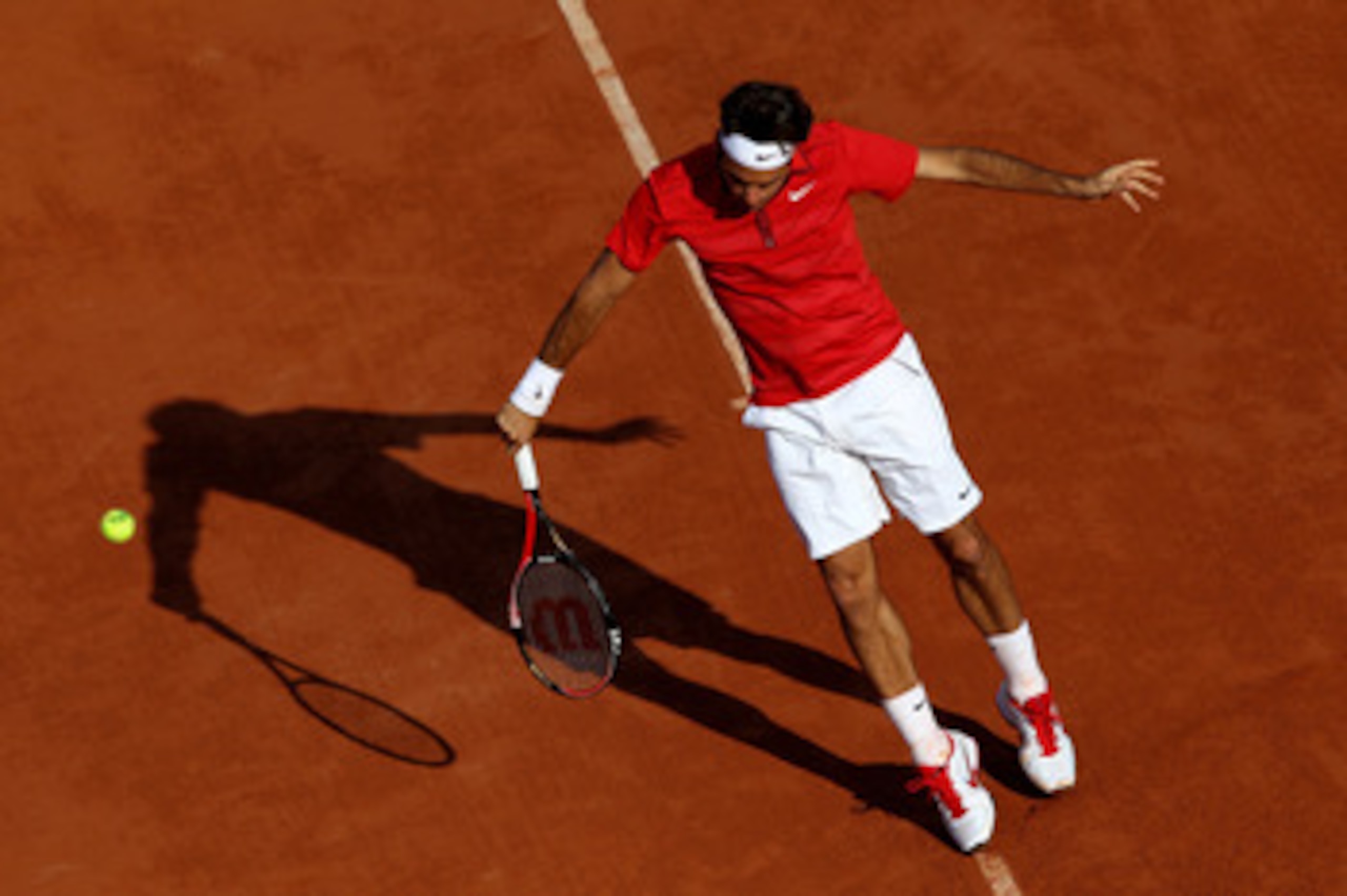 PARIS, FRANCE - MAY 31:  Roger Federer of Switzerland hits a backhand during the men's singles quarterfinal match between Gael Monfils of France and Roger Federer of Switzerland on day ten of the French Open at Roland Garros on May 31, 2011 in Paris, Fran