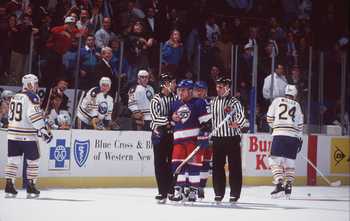 19 Nov 1993: DEFENSEMAN TIE DOMI #20 OF THE WINNIPEG JETS IS ESCORTED BY OFFICIALS PAST FORWARD ALEXANDER MOGILNY OF THE BUFFALO SABRES DURING A JETS GAME AGAINST THE SABRES AT THE AUD IN BUFFALO, NEW YORK.