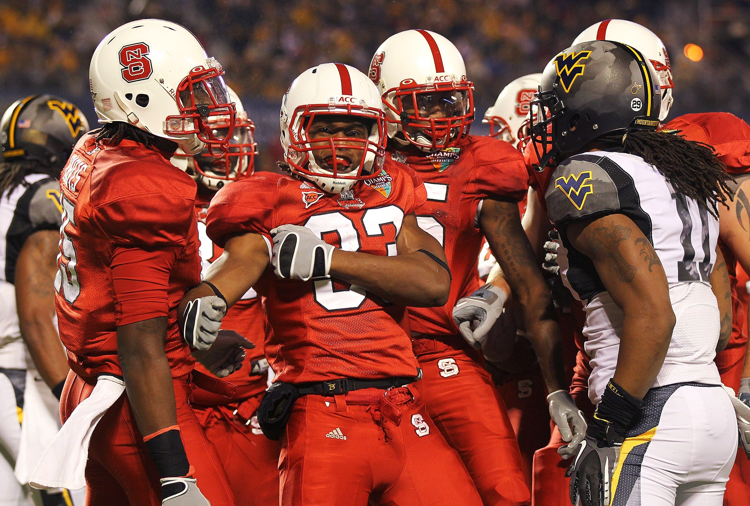 ORLANDO, FL - DECEMBER 28:  Mustafa Greene #33 of the North Carolina State Wolfpack is congratulated after scoring a touchdown during the Champs Sports Bowl against the West Virginia Mountineers at Florida Citrus Bowl Stadium on December 28, 2010 in Orlan