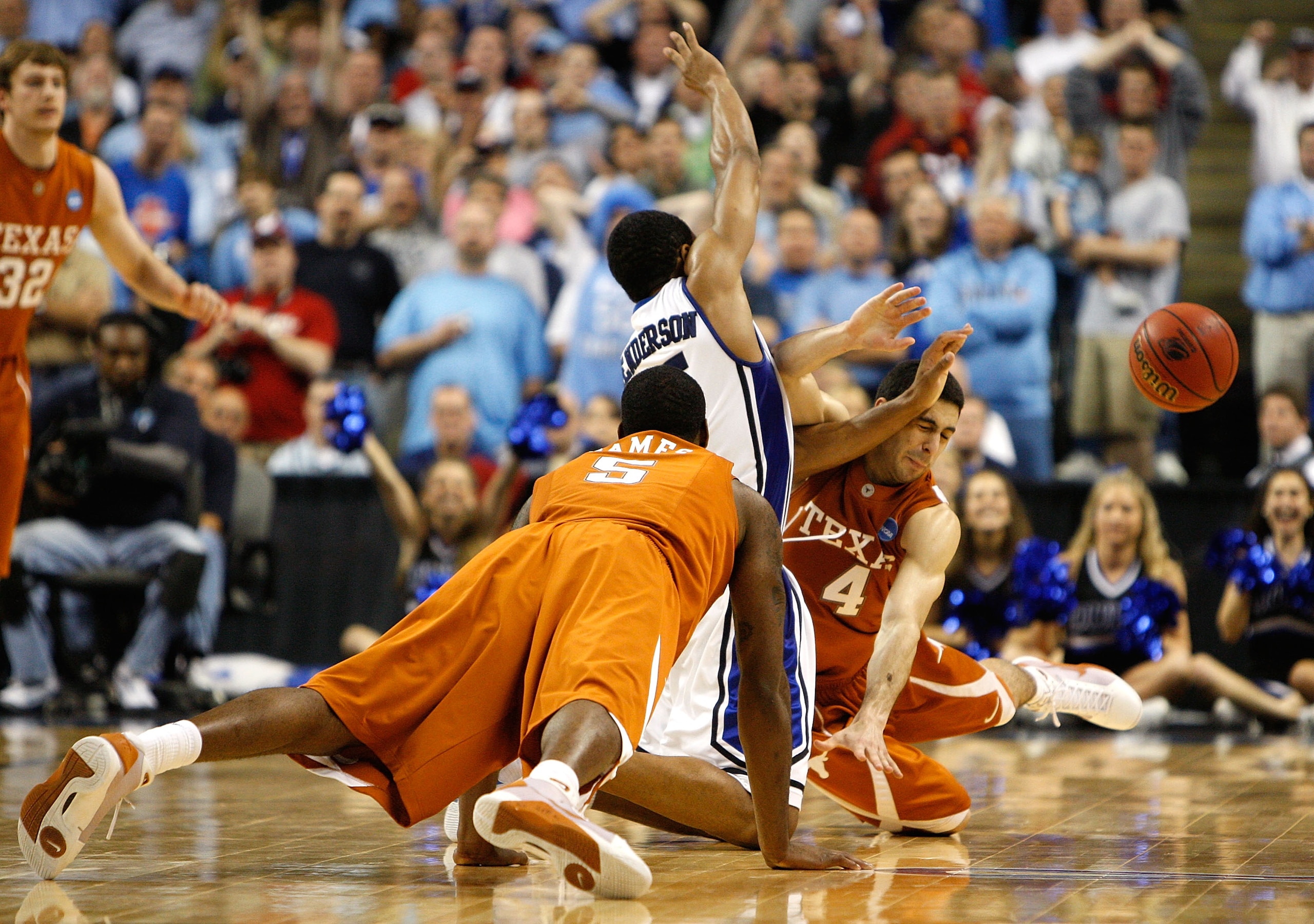 GREENSBORO, NC - MARCH 21:  Damion James #5 dives as Dogus Balbay #4 of the Texas Longhorns collides Gerald Henderson #15 of the Duke Blue Devils during the second round of the NCAA Division I Men's Basketball Tournament at the Greensboro Coliseum on Marc