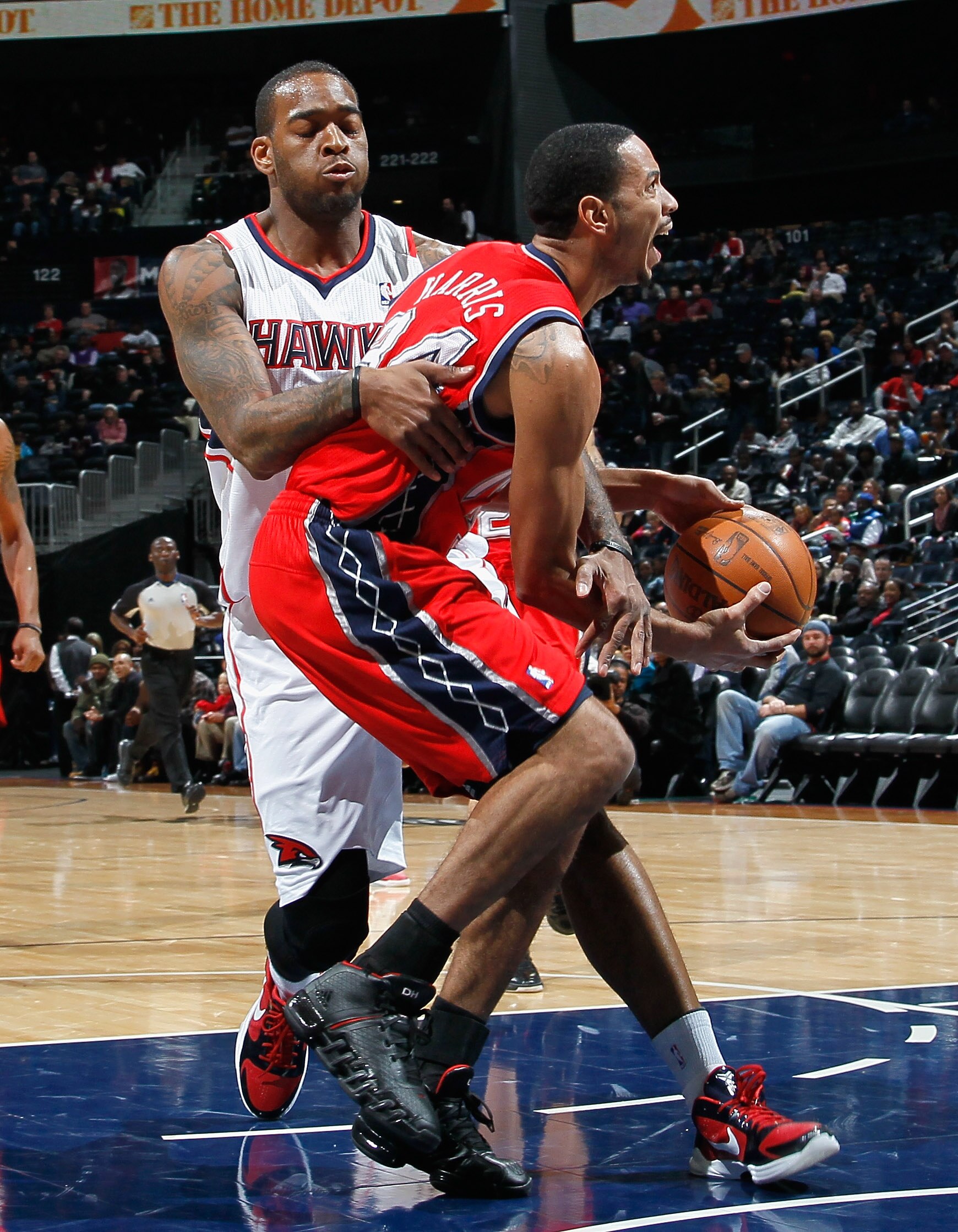 ATLANTA, GA - DECEMBER 07:  Josh Powell #12 of the Atlanta Hawks fouls Devin Harris #34 of the New Jersey Nets at Philips Arena on December 7, 2010 in Atlanta, Georgia.  NOTE TO USER: User expressly acknowledges and agrees that, by downloading and/or usin