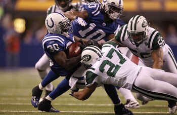 INDIANAPOLIS, IN - JANUARY 08:  Dominic Rhodes #30 of the Indianapolis Colts is tackled by Emanuel Cook #27 of the New York Jets during their 2011 AFC wild card playoff game at Lucas Oil Stadium on January 8, 2011 in Indianapolis, Indiana. The Jets won 17