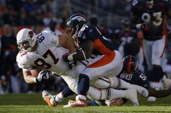 DENVER - DECEMBER 29:  Tight end Steve Bush #87 of the Arizona Cardinals is brought down by linebackers John Mobley #51 and Ian Gold #52 of the Denver Broncos during the game at Invesco Field at Mile High on December 29, 2002 in Denver, Colorado.  The Bro