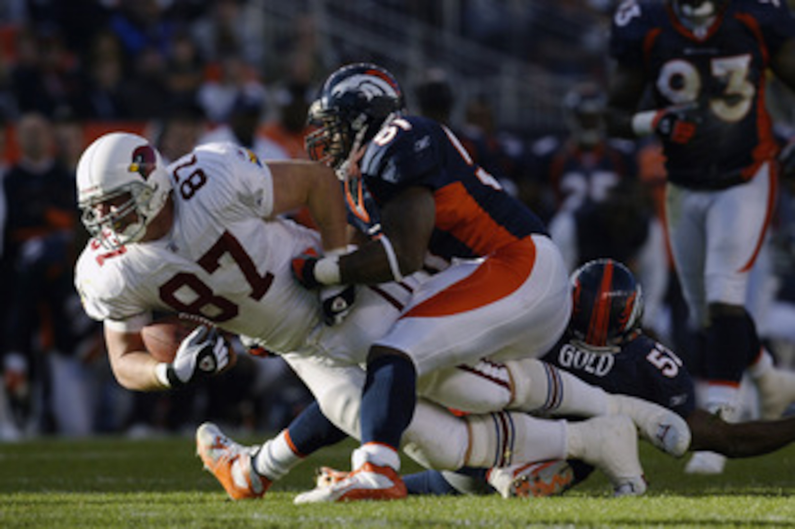 DENVER - DECEMBER 29:  Tight end Steve Bush #87 of the Arizona Cardinals is brought down by linebackers John Mobley #51 and Ian Gold #52 of the Denver Broncos during the game at Invesco Field at Mile High on December 29, 2002 in Denver, Colorado.  The Bro