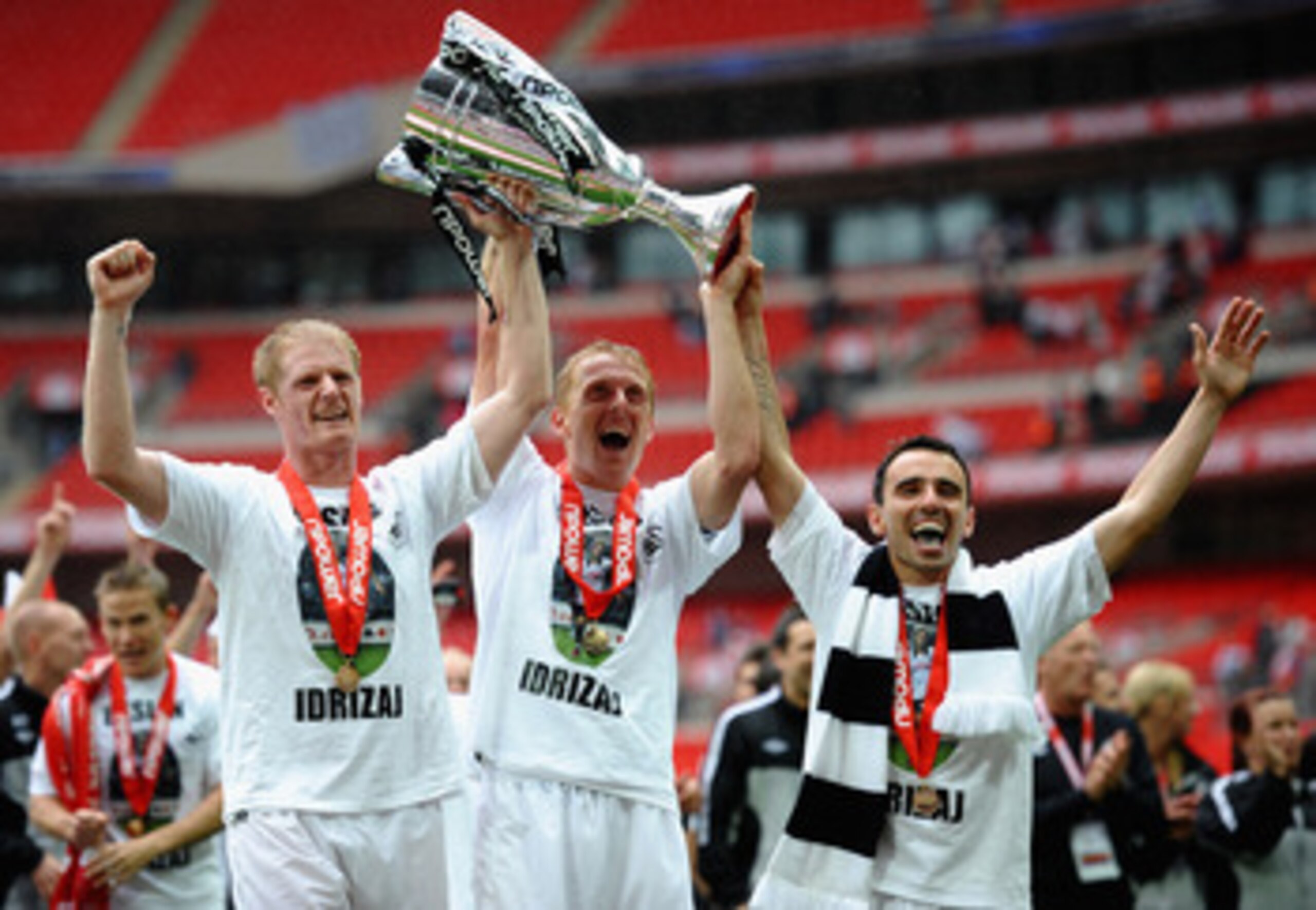 LONDON, ENGLAND - MAY 30: Garry Monk of Swansea (c) lifts the trophy as they celebrate promotion to the Premier League with Alan Tate (l) and Leon Britton during the npower Championship Playoff Final between Reading and Swansea City at Wembley Stadium on LONDON, ENGLAND - MAY 30: Garry Monk of Swansea (c) lifts the trophy as they celebrate promotion to the Premier League with Alan Tate (l) and Leon Britton during the npower Championship Playoff Final between Reading and Swansea City at Wembley Stadium on