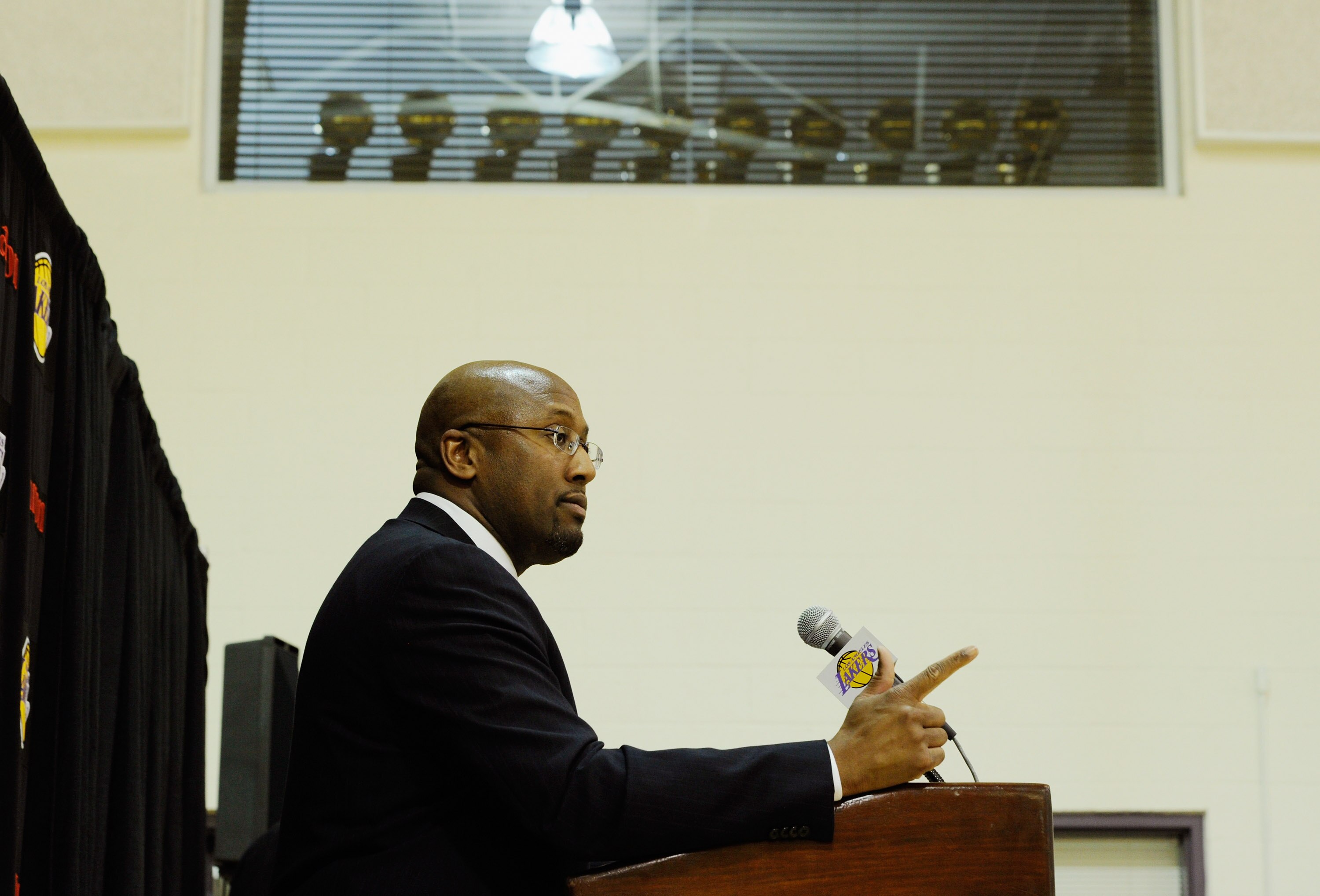EL SEGUNDO, CA - MAY 31:  With the Lakers World Championship trophies seen in the window above, Mike Brown, the new head coach for the Los Angeles Lakers, gives a speach during his introductory news conference at the team's training facility on May 31, 20
