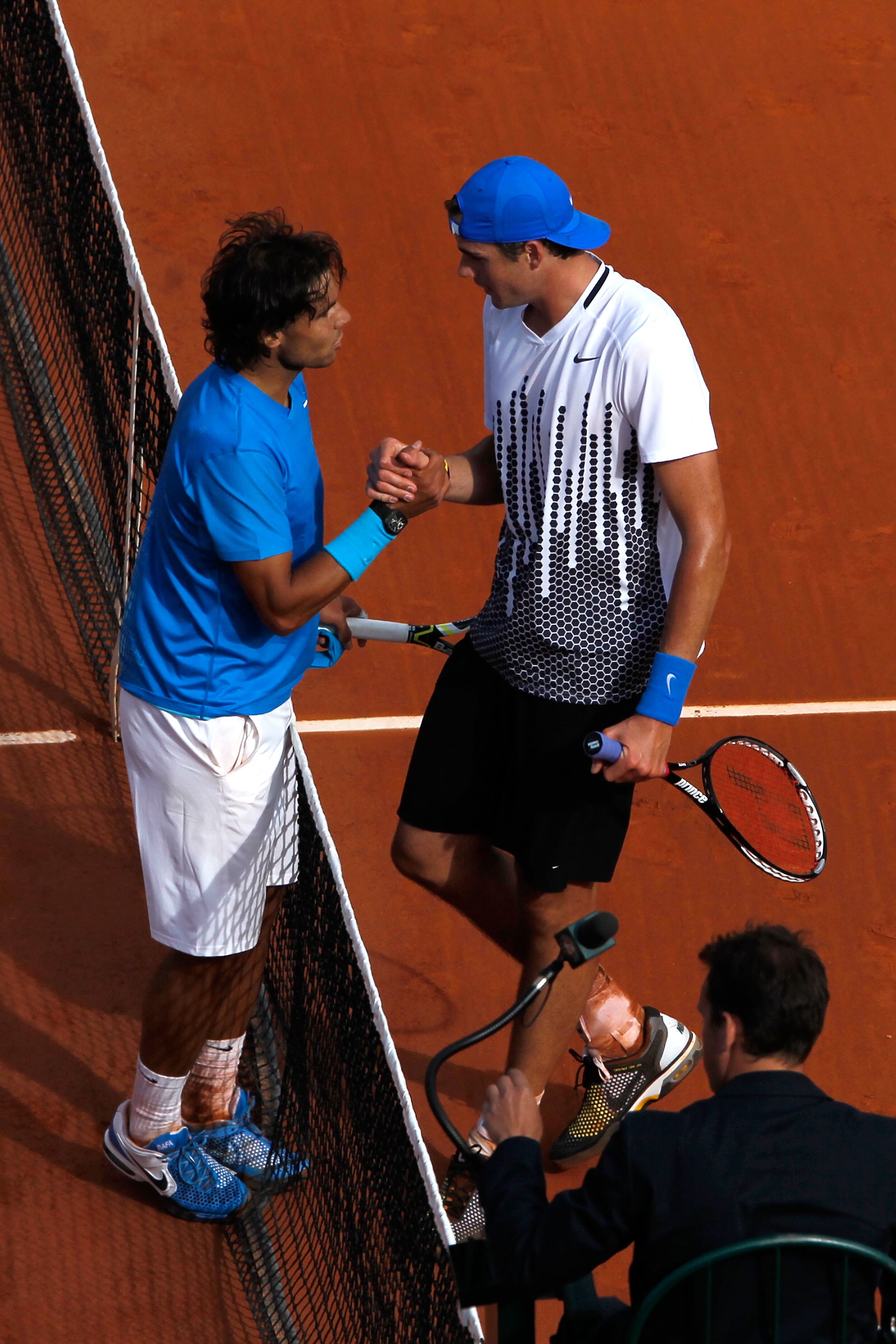 PARIS, FRANCE - MAY 24:  Rafael Nadal (L) of Spain shakes hands at the net with John Isner of USA after their men's singles round one match on day three of the French Open at Roland Garros on May 24, 2011 in Paris, France.  (Photo by Matthew Stockman/Gett
