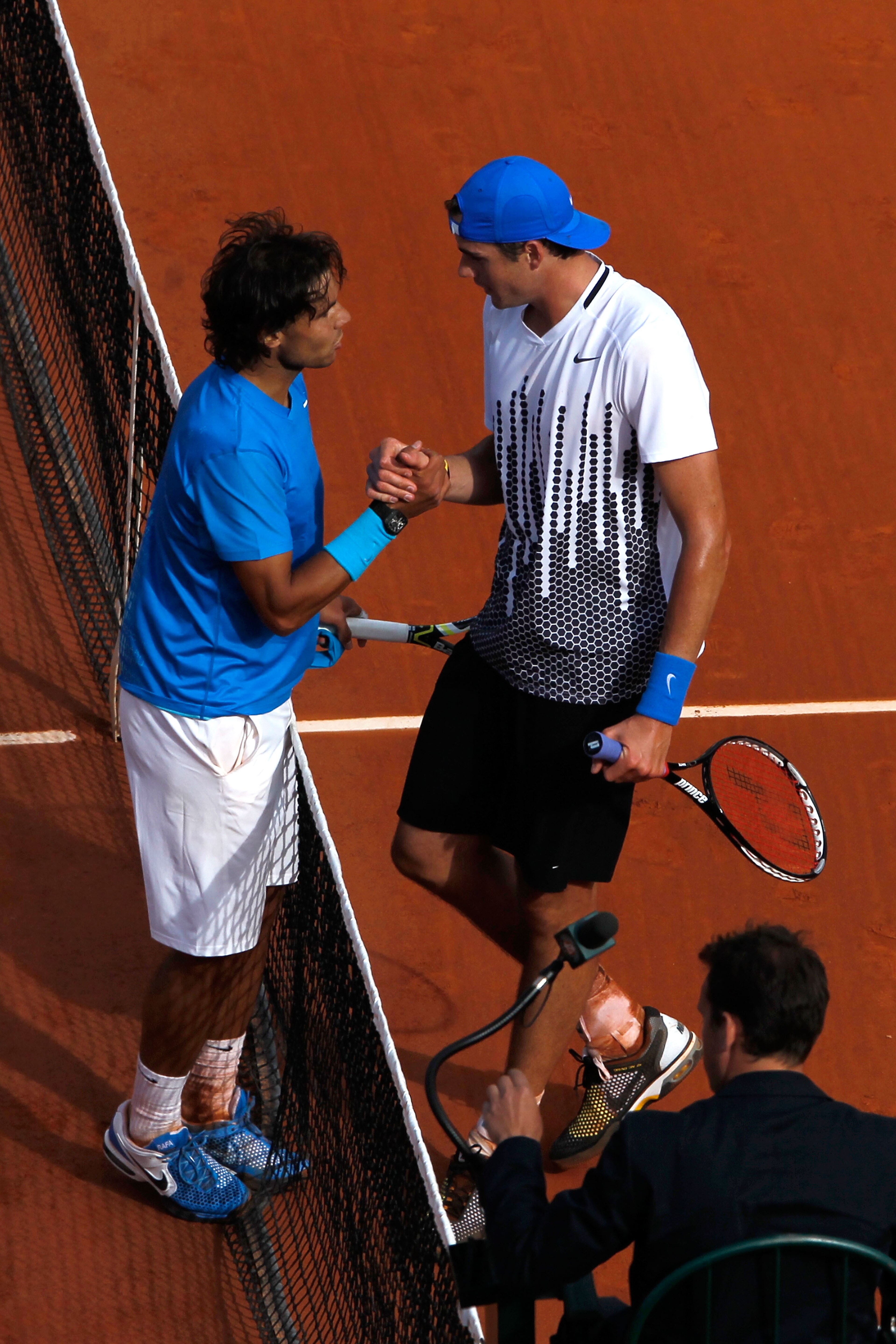 PARIS, FRANCE - MAY 24:  Rafael Nadal (L) of Spain shakes hands at the net with John Isner of USA after their men's singles round one match on day three of the French Open at Roland Garros on May 24, 2011 in Paris, France.  (Photo by Matthew Stockman/Gett