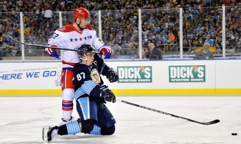 PITTSBURGH, PA - JANUARY 01:  Sidney Crosby #87 of the Pittsburgh Penguins battles for the puck against Mike Green #52 of the Washington Capitals during the 2011 NHL Bridgestone Winter Classic at Heinz Field on January 1, 2011 in Pittsburgh, Pennsylvania.