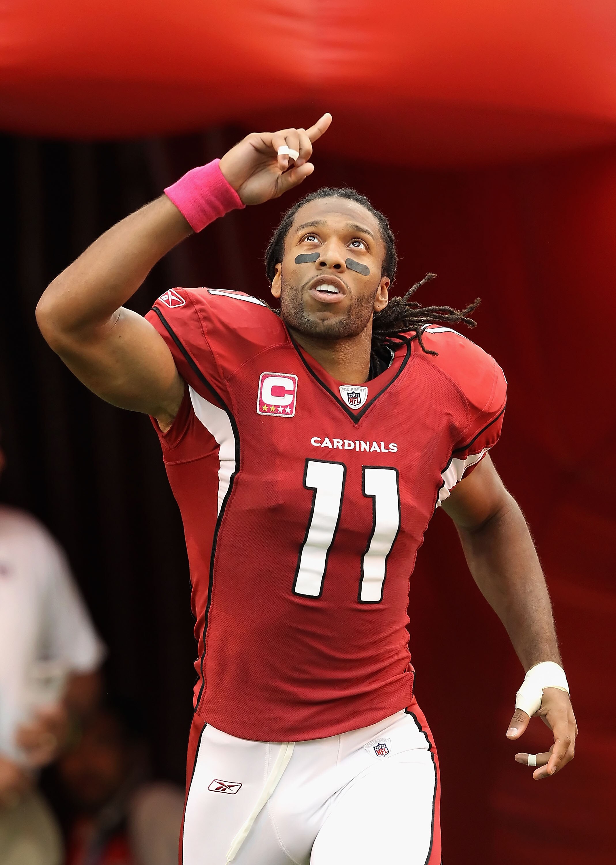 GLENDALE, AZ - OCTOBER 10:  Wide receiver Larry Fitzgerald #11 of the Arizona Cardinals runs onto the field during introductions to the NFL game against the New Orleans Saints at the University of Phoenix Stadium on October 10, 2010 in Glendale, Arizona.