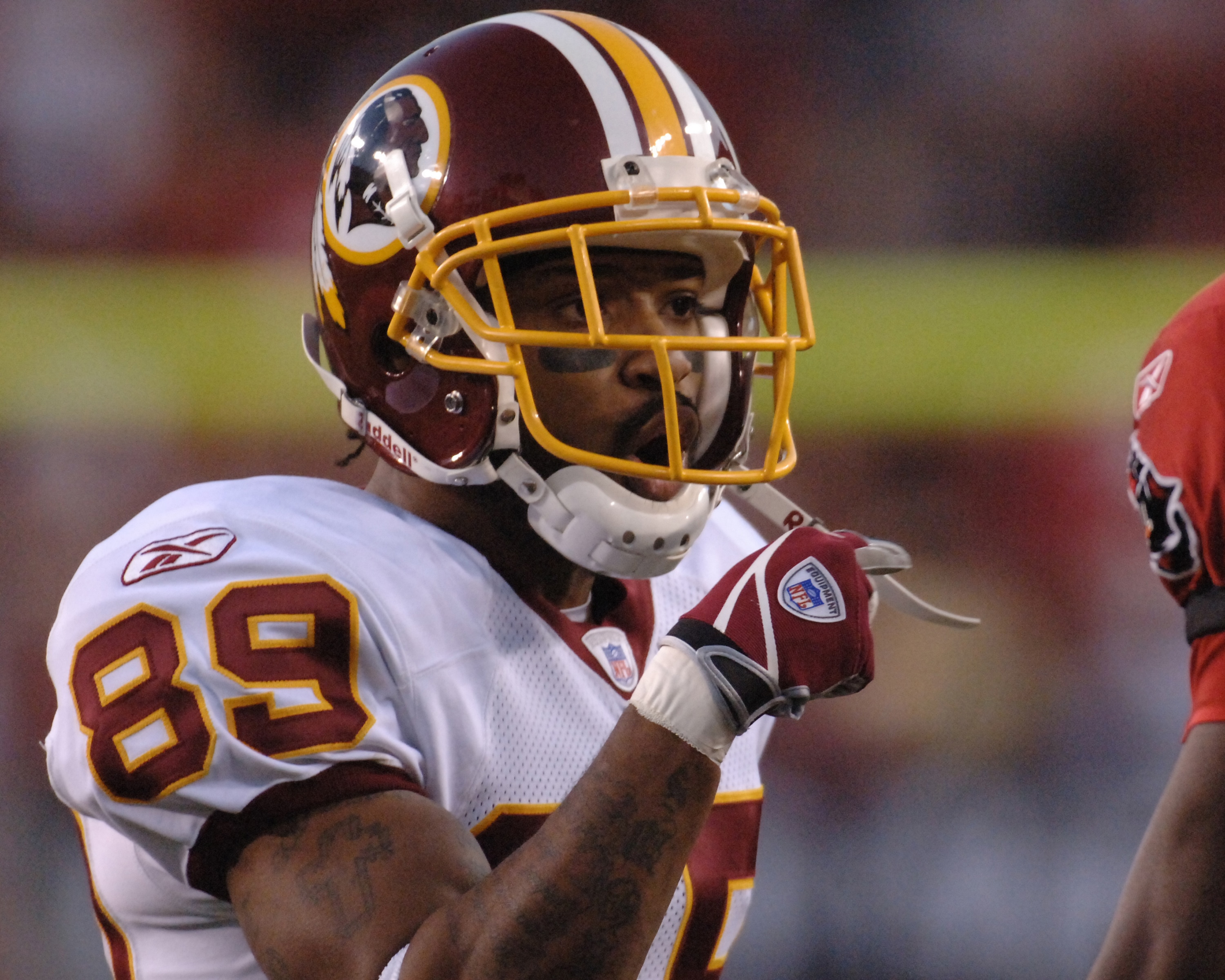 Washington Redskins wide receiver Santana Moss talks to a  Tampa Bay Buccaneers defender during  an NFL wild card playoff game January 7, 2006 in Tampa.  The Redskins defeated the Bucs 17 - 10.  (Photo by Al Messerschmidt/Getty Images)