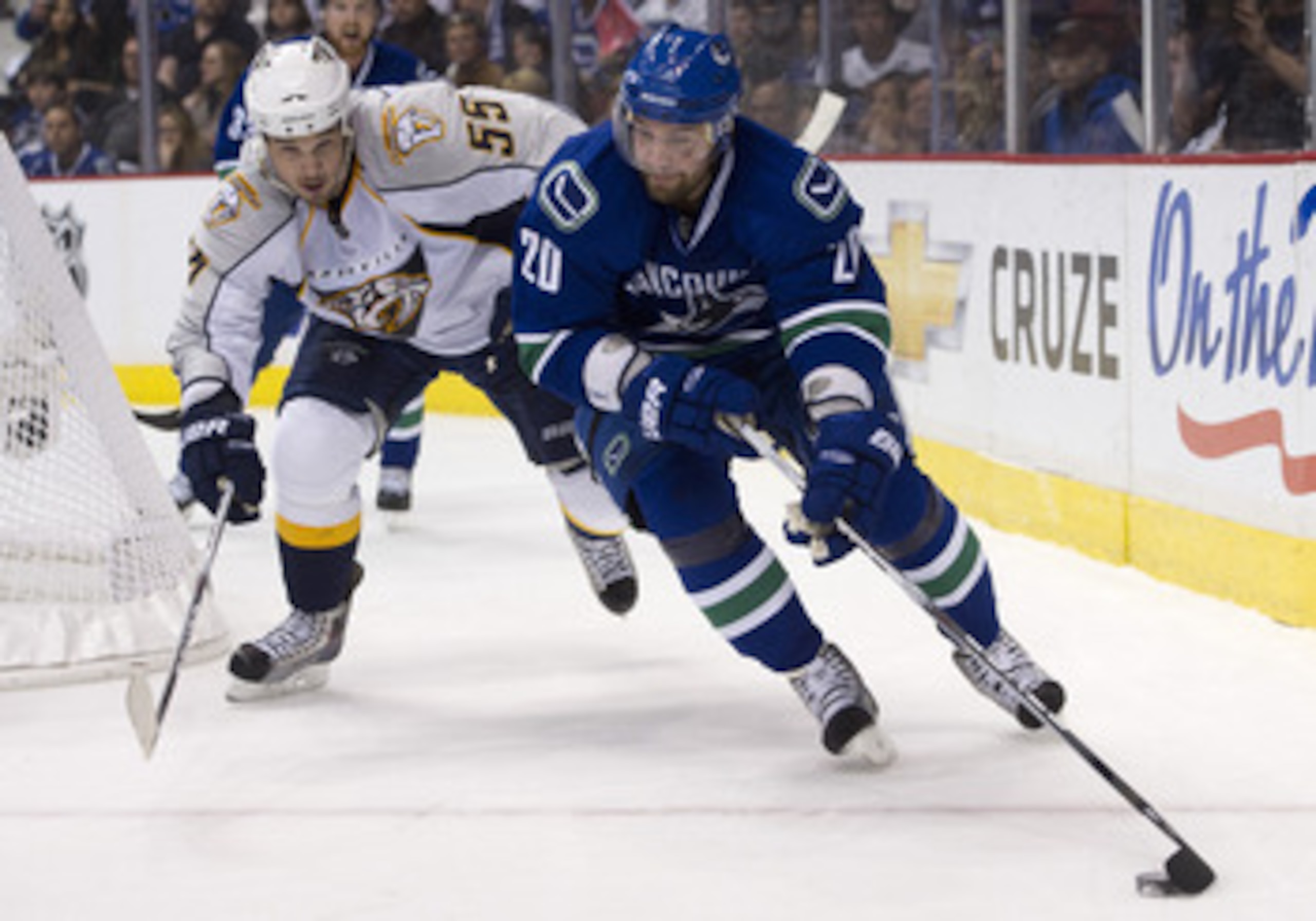 VANCOUVER, CANADA - APRIL 30: Chris Higgins #20 of the Vancouver Canucks handles the puck while being chased by Shane O'Brien #55 of the Nashville Predators during the second period in Game Two of the Western Conference Semifinals during the 2011 NHL Stan