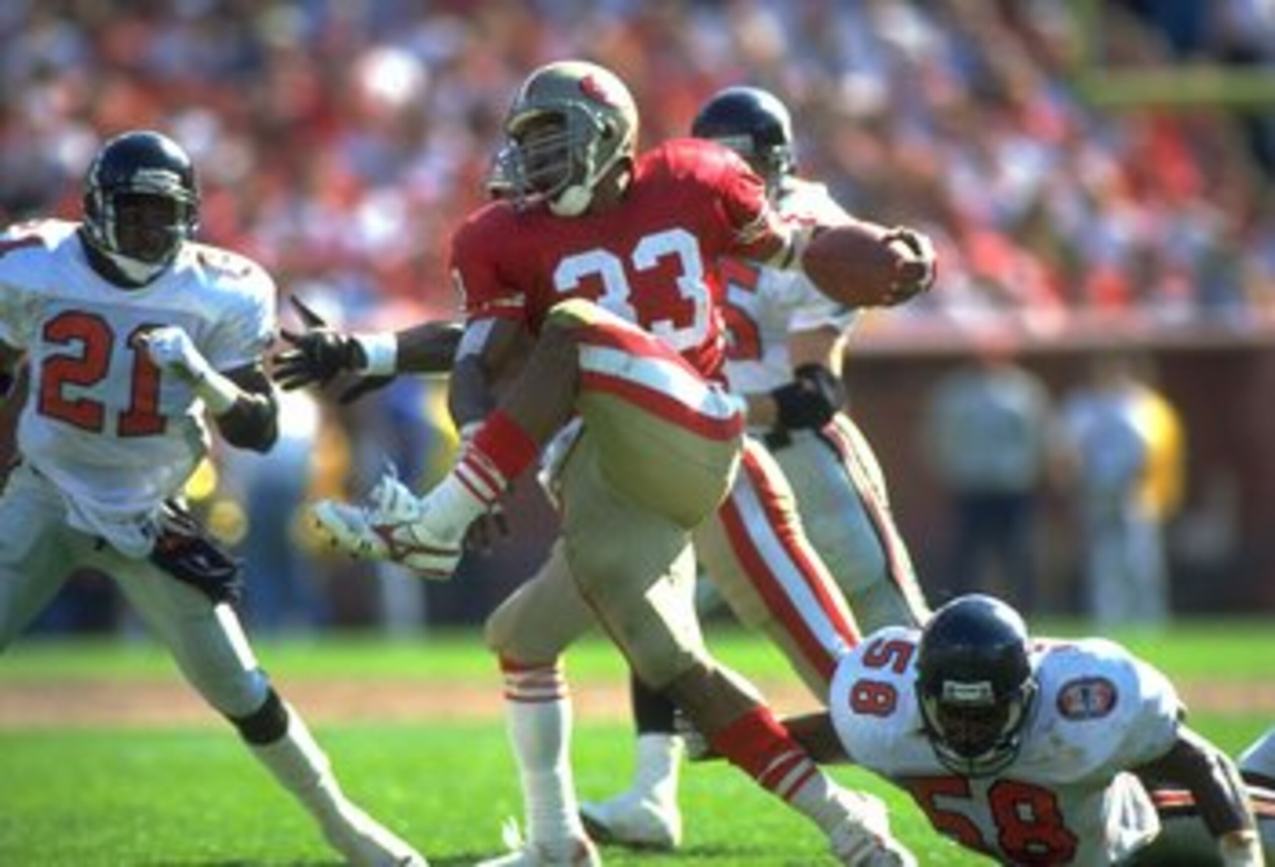 23 SEP 1990: SAN FRANCISCO 49ERS RUNNING BACK ROGER CRAIG #33 HIGH STEPS THROUGH ATLANTA FALCONS LINEBACKER JESSIE TUGGLE #58 AND DEFENSIVE BACK DEION SANDERS #21, DURING THE 49ERS 19-13 WIN AT CANDLESTICK PARK IN SAN FRANCISCO, CALIFORNIA. 23 SEP 1990: SAN FRANCISCO 49ERS RUNNING BACK ROGER CRAIG #33 HIGH STEPS THROUGH ATLANTA FALCONS LINEBACKER JESSIE TUGGLE #58 AND DEFENSIVE BACK DEION SANDERS #21, DURING THE 49ERS 19-13 WIN AT CANDLESTICK PARK IN SAN FRANCISCO, CALIFORNIA.