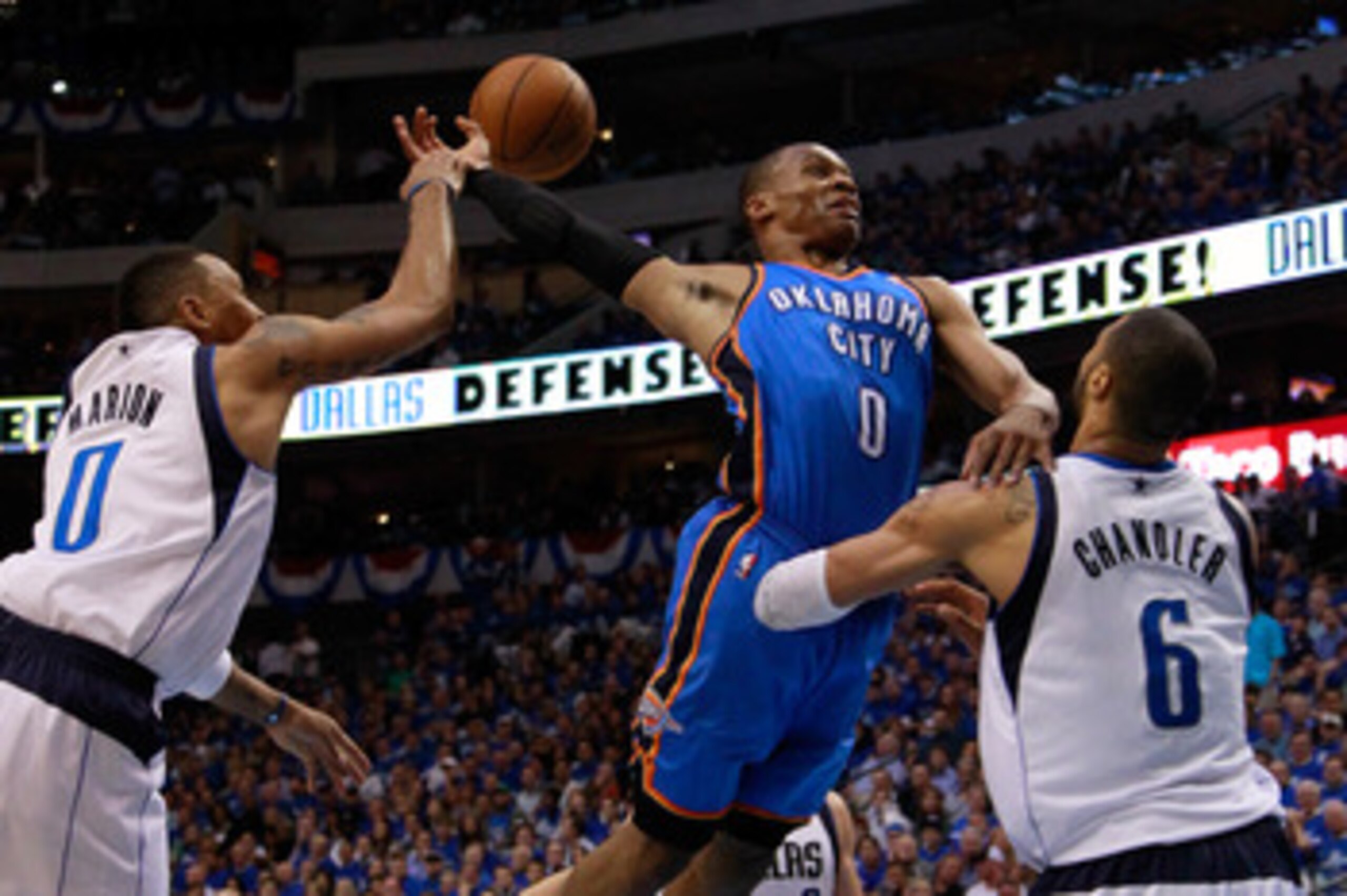 DALLAS, TX - MAY 25:  Russell Westbrook #0 of the Oklahoma City Thunder goes up for a dunk as Shawn Marion #0 of the Dallas Mavericks attempts to block the dunk as Westbrook crashes into Tyson Chandler #6 of the Mavericks in Game Five of the Western Confe