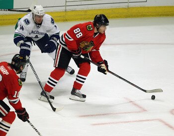 CHICAGO, IL - APRIL 24: Patrick Kane #88 of the Chicago Blackhawks shoots the puck in front of Alexandre Burrows #14 of the Vancouver Canucks in Game Six of the Western Conference Quarterfinals during the 2011 NHL Stanley Cup Playoffs at the United Center