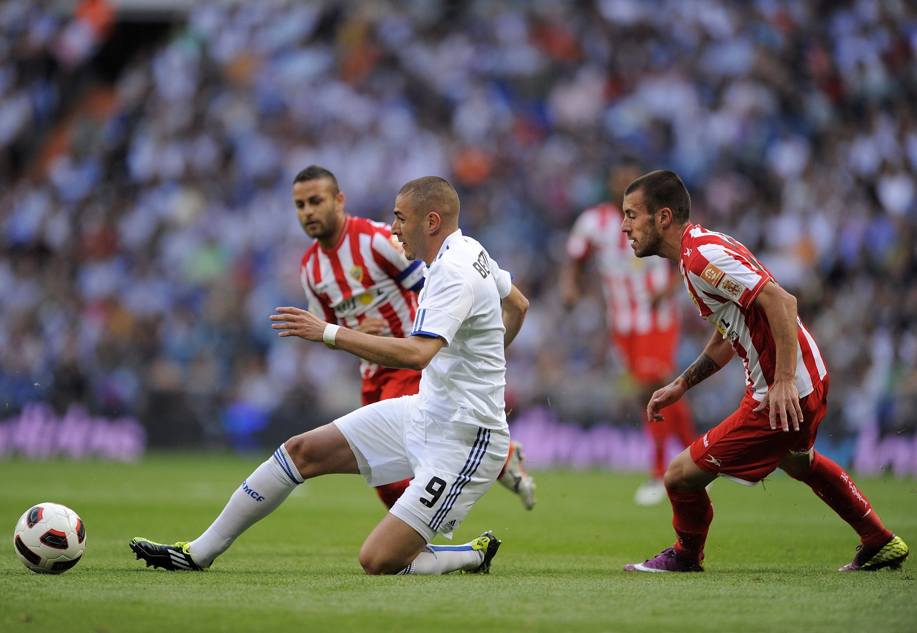MADRID, SPAIN - MAY 21:  Karim Benzema (L) of Real Madrid passes the ball beside Rigo of UD Almeria during the La Liga match between Real Madrid and UD Almeria at Estadio Santiago Bernabeu on May 21, 2011 in Madrid, Spain.  (Photo by Denis Doyle/Getty Ima