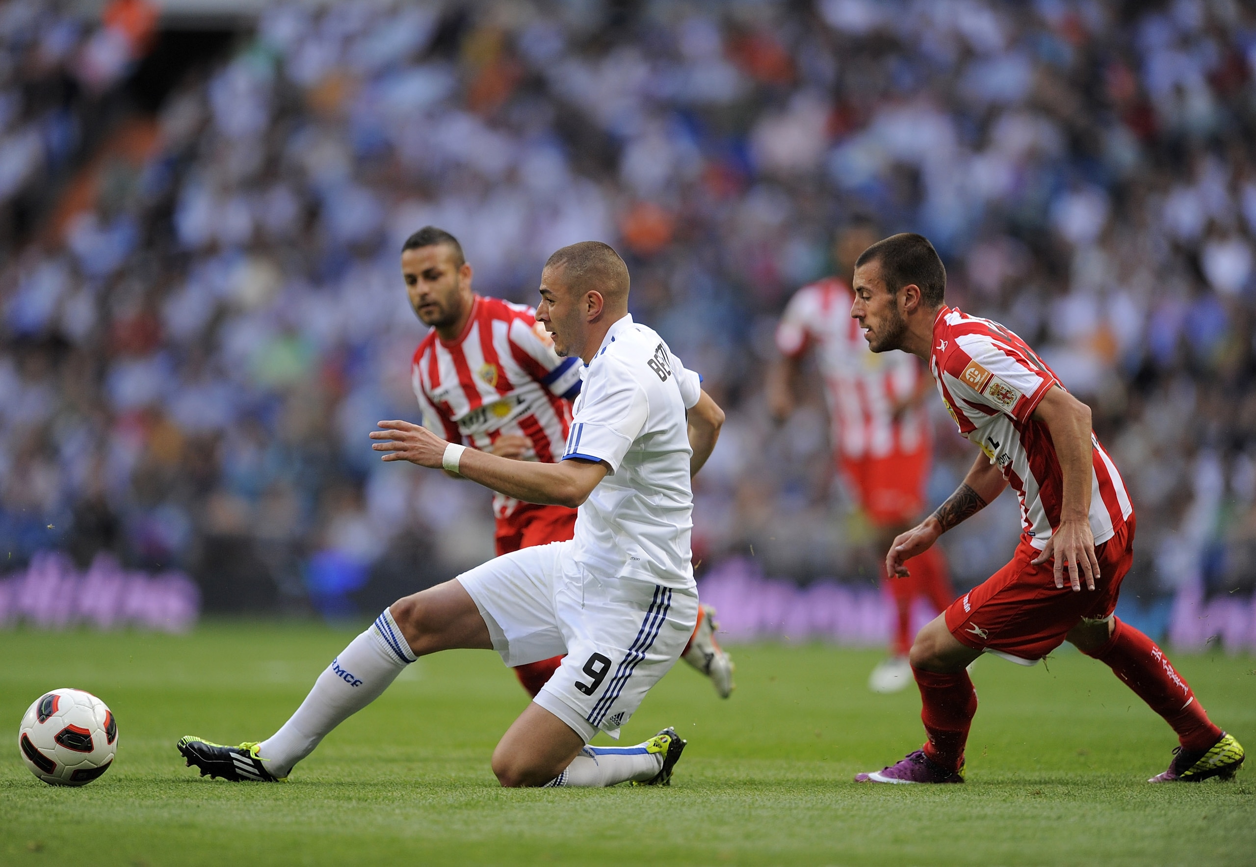 MADRID, SPAIN - MAY 21:  Karim Benzema (L) of Real Madrid passes the ball beside Rigo of UD Almeria during the La Liga match between Real Madrid and UD Almeria at Estadio Santiago Bernabeu on May 21, 2011 in Madrid, Spain.  (Photo by Denis Doyle/Getty Ima
