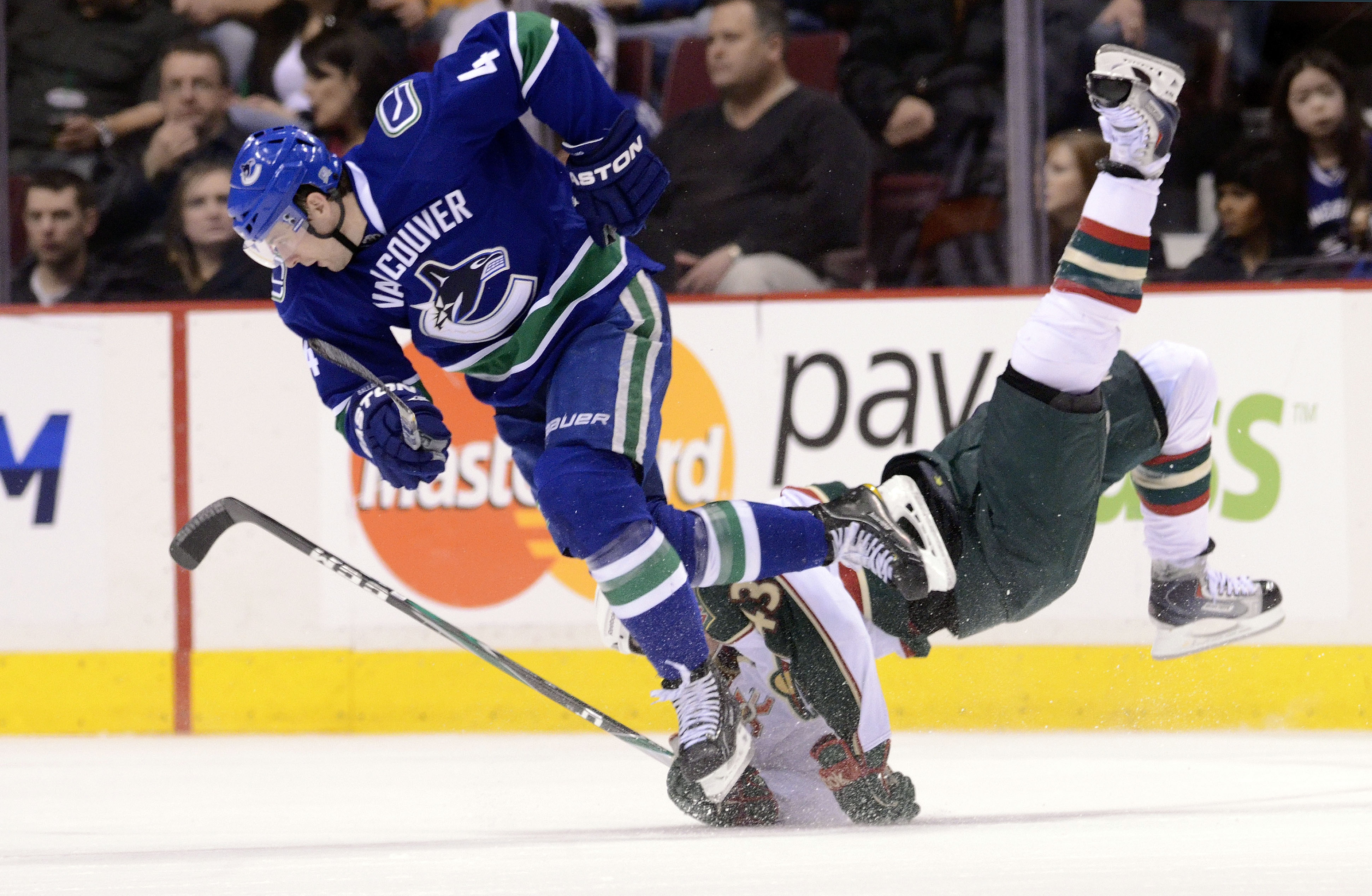 VANCOUVER, CANADA - MARCH 14: Keith Ballard #4 of the Vancouver Canucks sends Warren Peters #43 of the Minnesota Wild flying with a hip check during the second period in NHL action on March 14, 2011 at Rogers Arena in Vancouver, British Columbia, Canada.