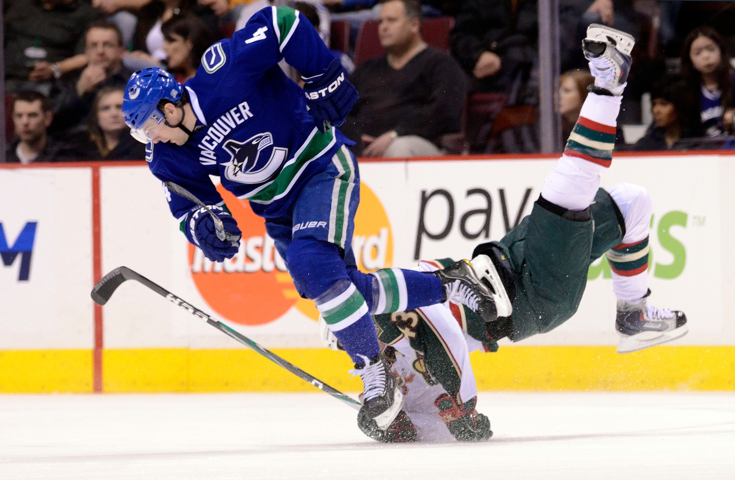 VANCOUVER, CANADA - MARCH 14: Keith Ballard #4 of the Vancouver Canucks sends Warren Peters #43 of the Minnesota Wild flying with a hip check during the second period in NHL action on March 14, 2011 at Rogers Arena in Vancouver, British Columbia, Canada. VANCOUVER, CANADA - MARCH 14: Keith Ballard #4 of the Vancouver Canucks sends Warren Peters #43 of the Minnesota Wild flying with a hip check during the second period in NHL action on March 14, 2011 at Rogers Arena in Vancouver, British Columbia, Canada.