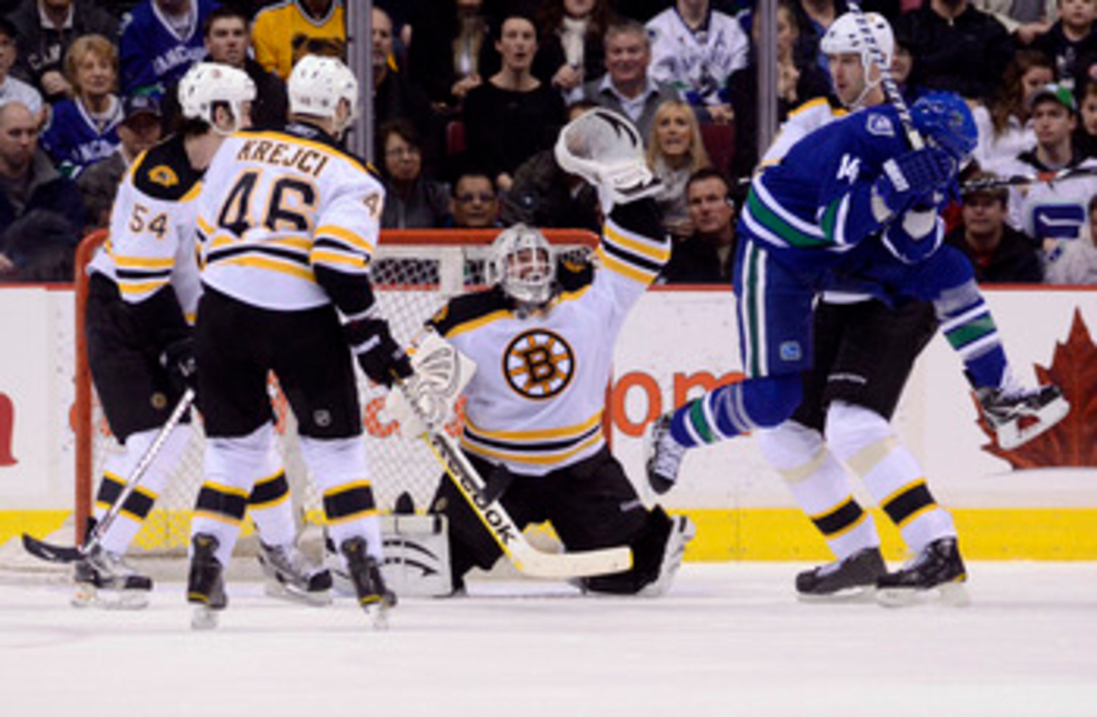 VANCOUVER, CANADA - FEBRUARY 26: Alexandre Burrows #14 of the Vancouver Canucks jumps out of the way of a shot as the puck sails over the head of goalie Tim Thomas #30 of the Boston Bruins during the third period in NHL action on February 26, 2011 at Roge