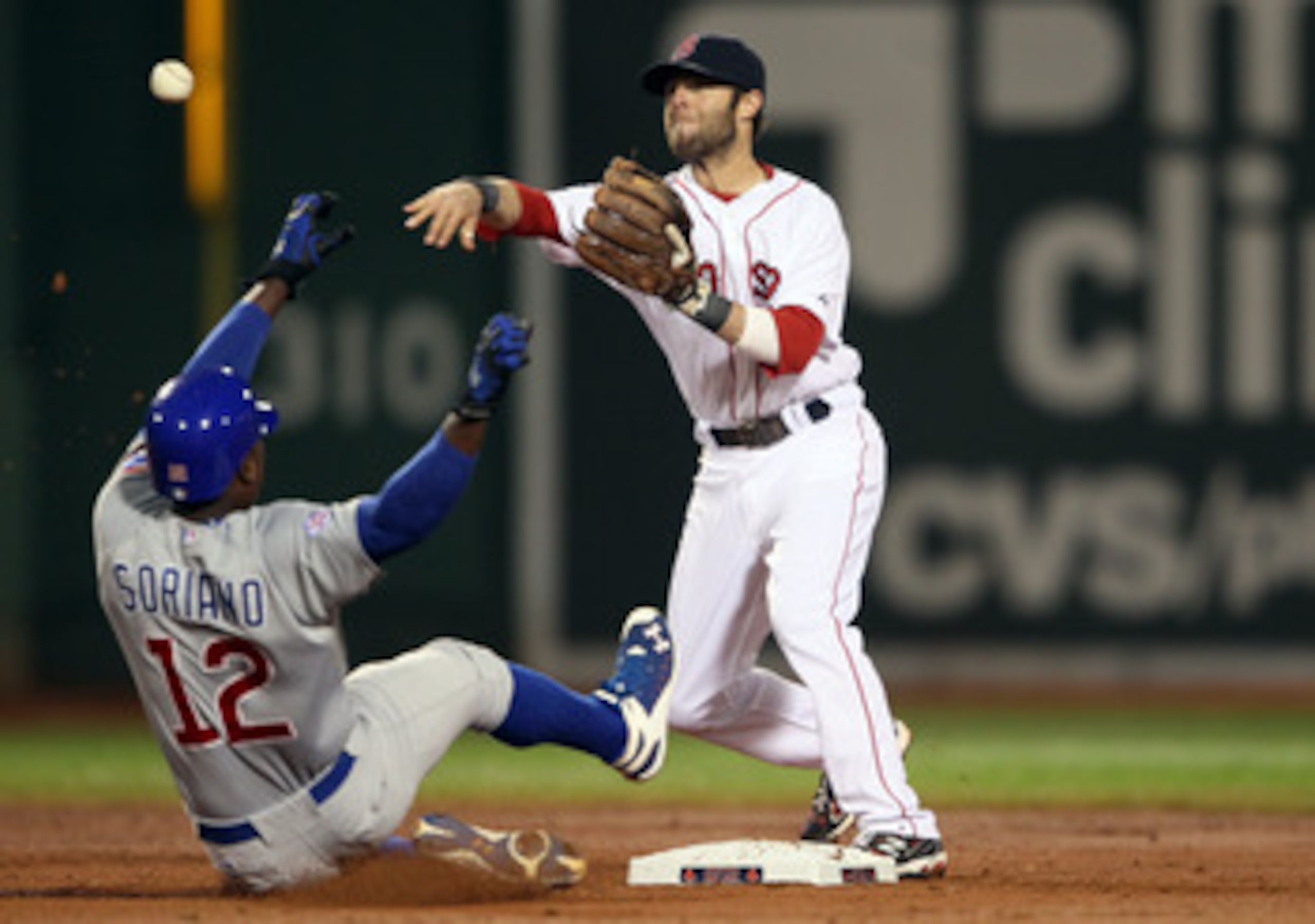BOSTON, MA - MAY 22:  Dustin Pedroia #15 of the Boston Red Sox turns the double play as Alfonso Soriano #12 of the Chicago Cubs is out at second in the third inning on May 22, 2011 at Fenway Park in Boston, Massachusetts.  Before this series, the two team