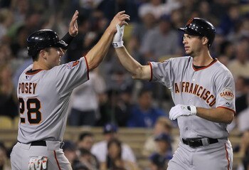 LOS ANGELES, CA - APRIL 01:  Brandon Belt (R) #9 of the San Francisco Giants is congratulated by Buster Posey #28 after hitting a three-run home run against the Los Angeles Dodgers in the fourth inning at Dodger Stadium on April 1, 2011 in Los Angeles, Ca