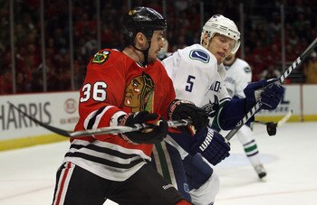 CHICAGO, IL - APRIL 24: Dave Bolland #36 and Christian Ehrhoff #5 of the Chicago Blackhawks of the Vancouver Canucks battle for the puck in Game Six of the Western Conference Quarterfinals during the 2011 NHL Stanley Cup Playoffs at the United Center on A