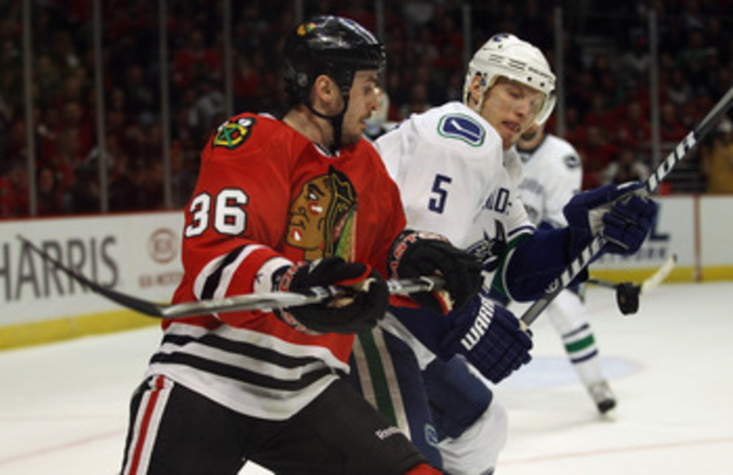 CHICAGO, IL - APRIL 24: Dave Bolland #36 and Christian Ehrhoff #5 of the Chicago Blackhawks of the Vancouver Canucks battle for the puck in Game Six of the Western Conference Quarterfinals during the 2011 NHL Stanley Cup Playoffs at the United Center on A
