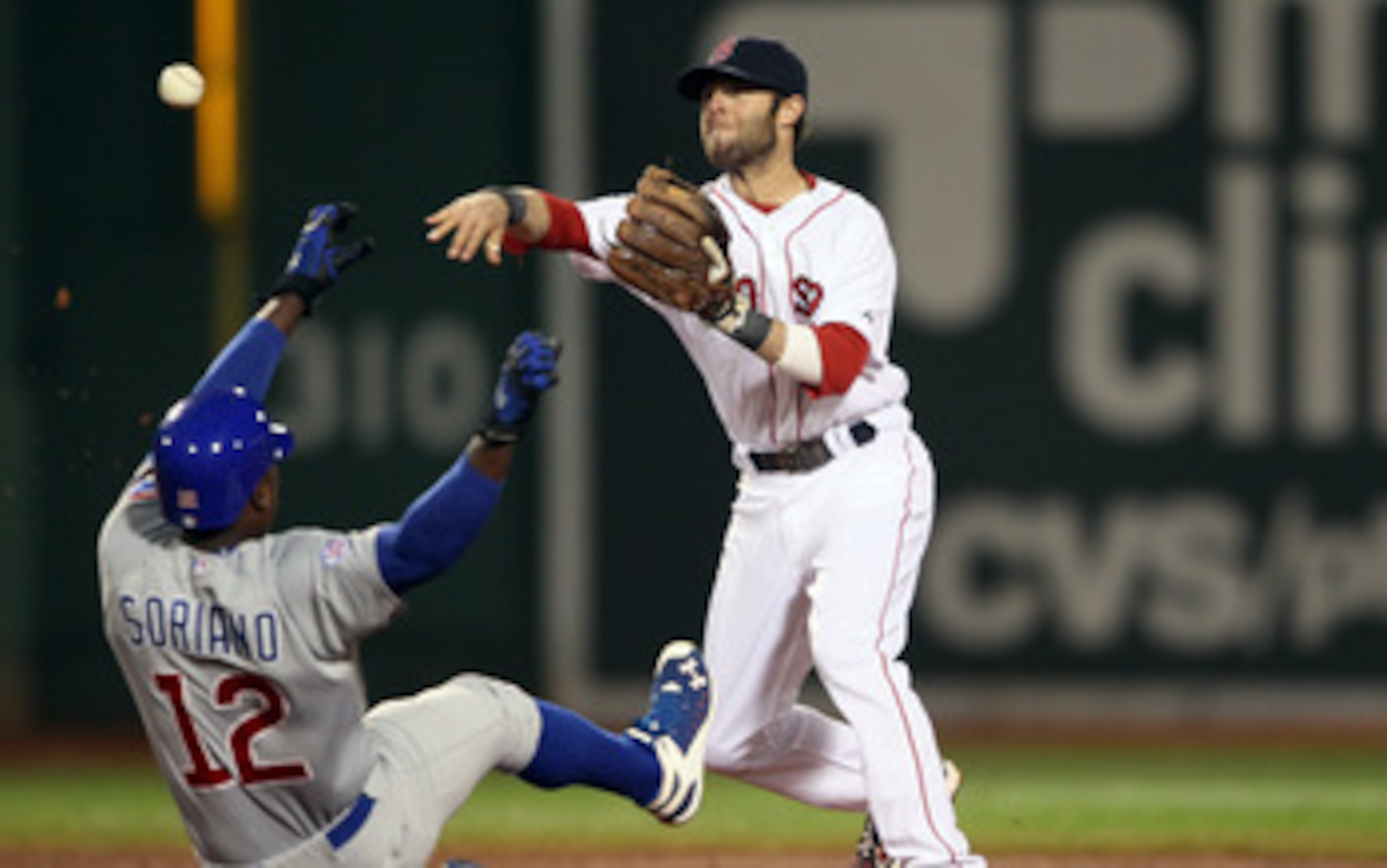 BOSTON, MA - MAY 22:  Dustin Pedroia #15 of the Boston Red Sox turns the double play as Alfonso Soriano #12 of the Chicago Cubs is out at second in the third inning on May 22, 2011 at Fenway Park in Boston, Massachusetts.  Before this series, the two team