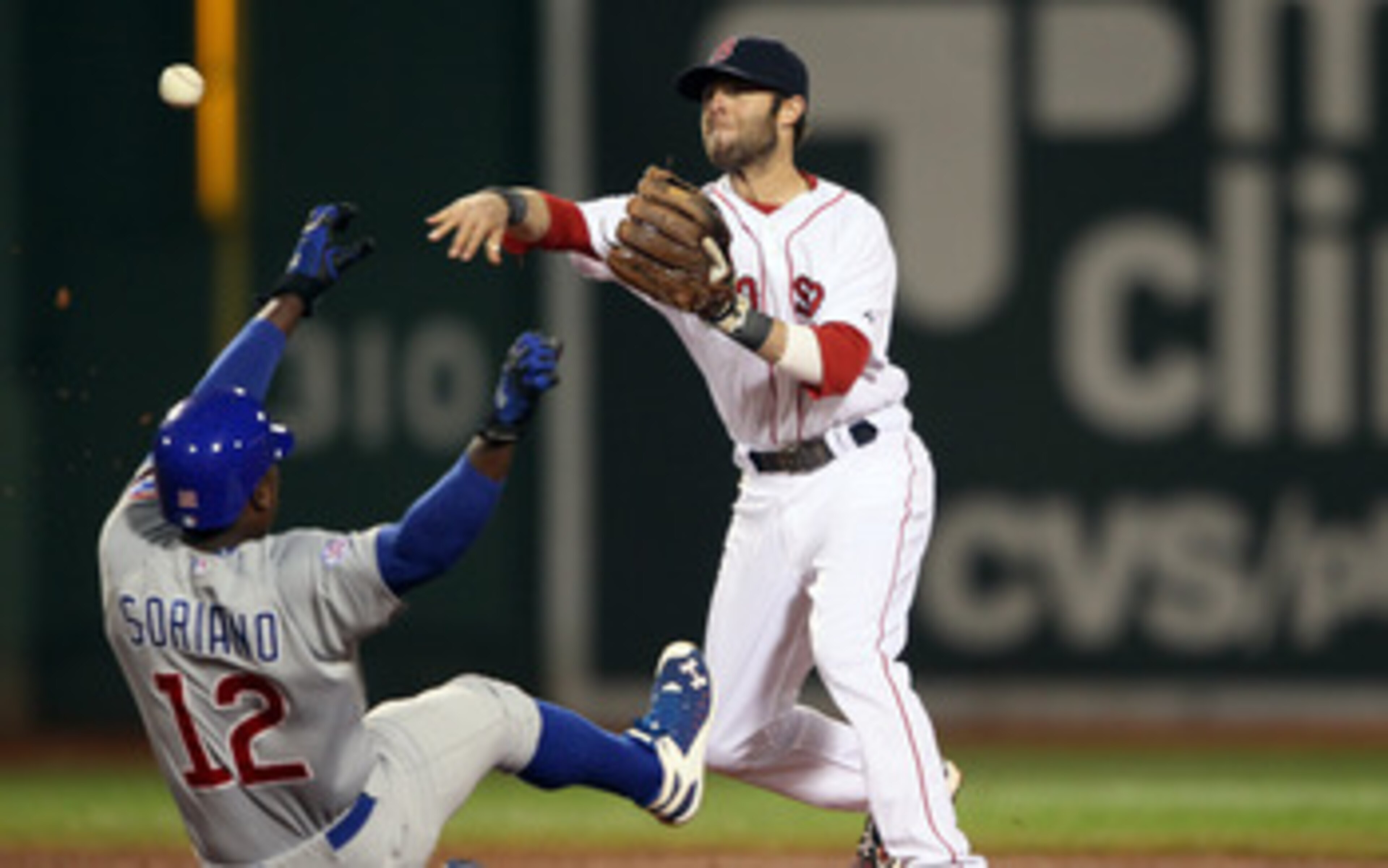 BOSTON, MA - MAY 22:  Dustin Pedroia #15 of the Boston Red Sox turns the double play as Alfonso Soriano #12 of the Chicago Cubs is out at second in the third inning on May 22, 2011 at Fenway Park in Boston, Massachusetts.  Before this series, the two team