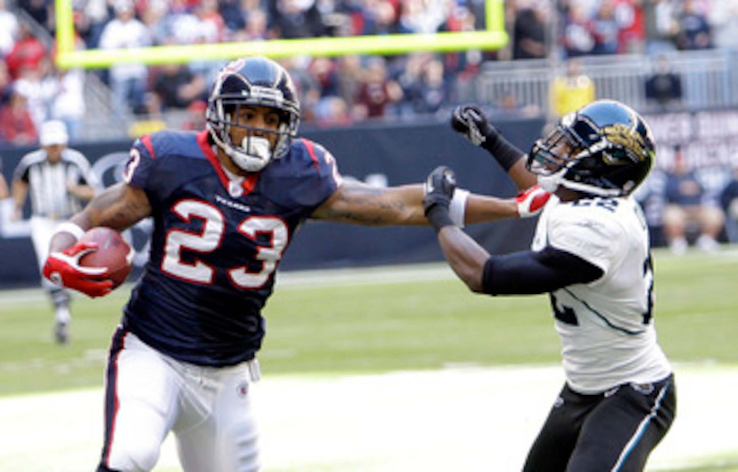 HOUSTON - JANUARY 02:  Running back Arian Foster #23 of the Houston Texans gives Don Carey #22 of the Jacksonville Jaguars a stiff arm at Reliant Stadium on January 2, 2011 in Houston, Texas.  (Photo by Bob Levey/Getty Images)