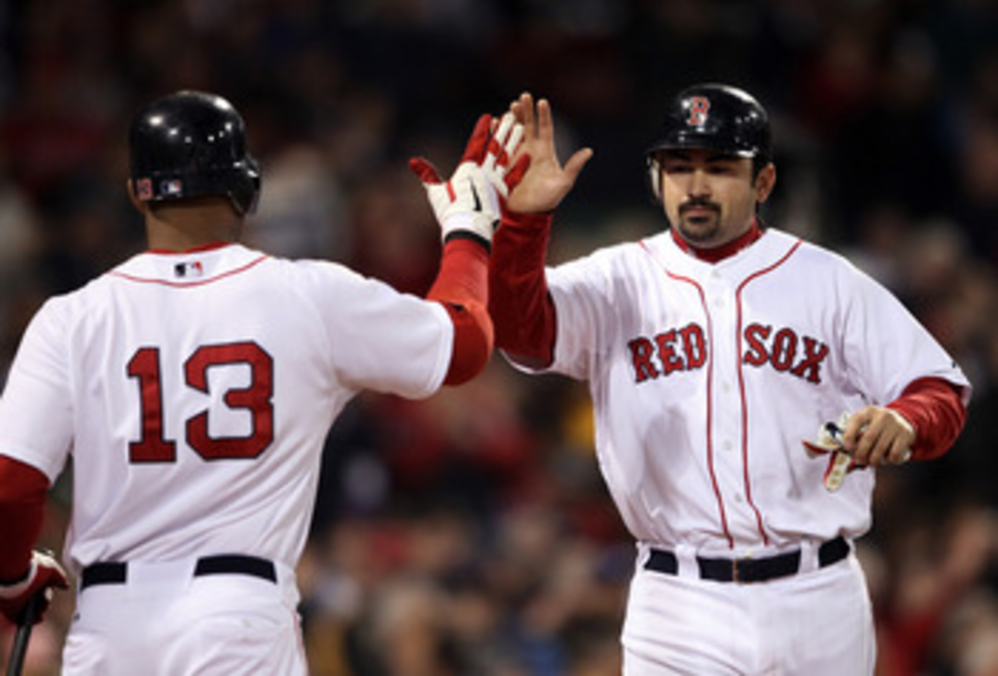 BOSTON, MA - MAY 22:  Adrian Gonzalez #28 of the Boston Red Sox is congratulated by teammate Carl Crawford #13 after Gonzalez scored in the fourth inning against the Chicago Cubs on May 22, 2011 at Fenway Park in Boston, Massachusetts.  Before this series