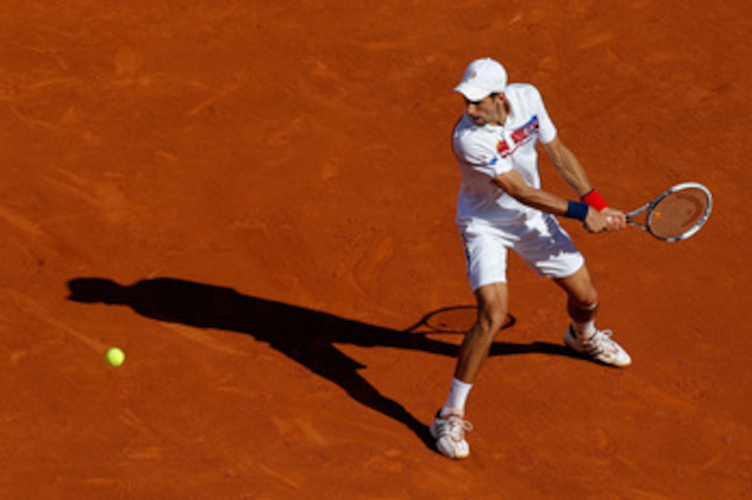PARIS, FRANCE - MAY 29:  Novak Djokovic of Serbia hits a backhand during the men's singles round four match between Richard Gasquet of France and Novak Djokovic of Serbia on day eight of the French Open at Roland Garros on May 29, 2011 in Paris, France.  