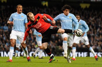 MANCHESTER, UNITED KINGDOM - JANUARY 19:   Wayne Rooney of Manchester United battles for the ball with Carlos Tevez of Manchester City during the Carling Cup Semi Final match between Manchester City and Manchester United at the City of Manchester Stadium