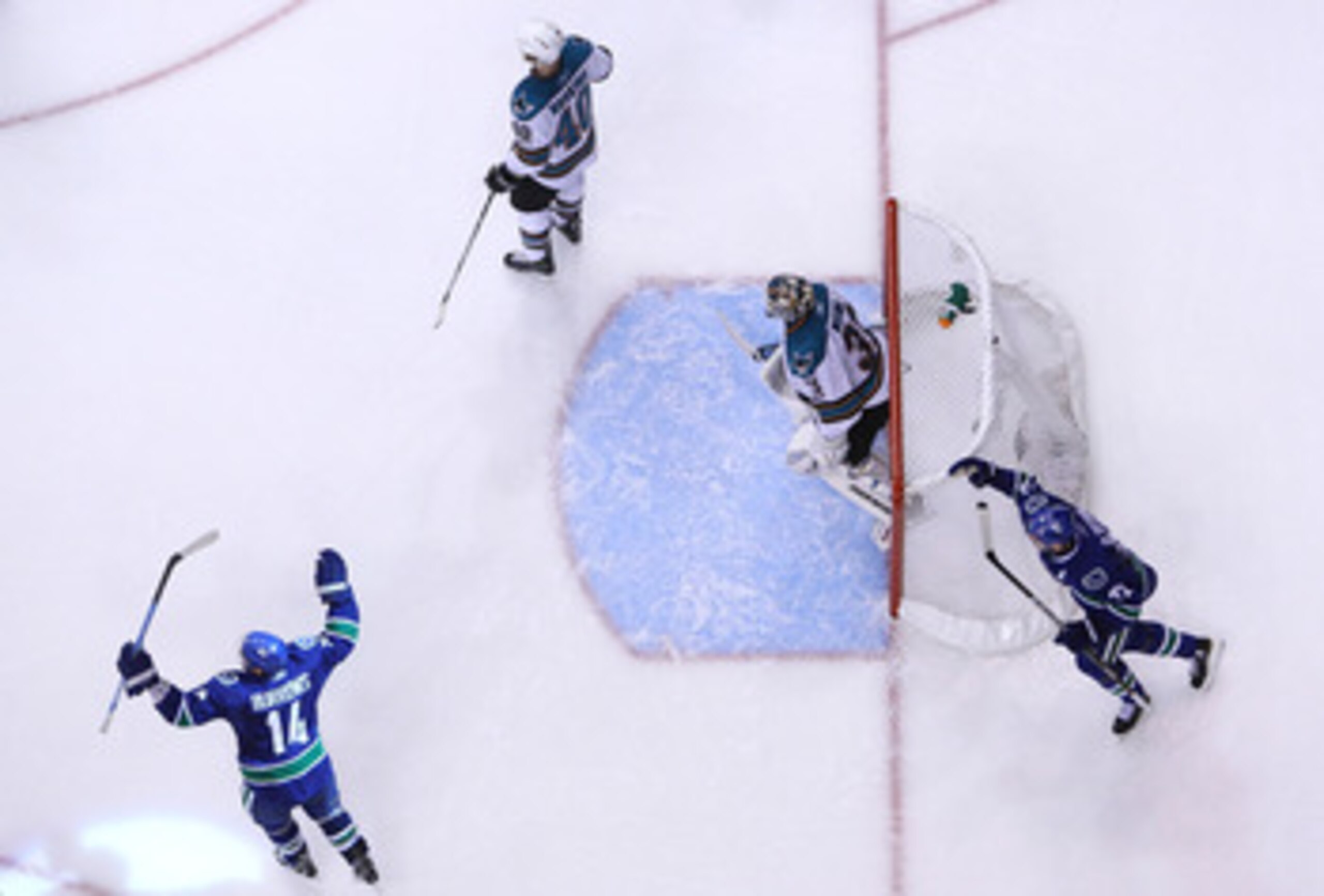 VANCOUVER, BC - MAY 24:  Goaltender Antti Niemi #31 and Kent Huskins #40 of the San Jose Sharks look on as Alex Burrows #14 and Daniel Sedin #22 of the Vancouver Canucks celebrate after a goal by teammate Kevin Bieksa #3 (not in photo) wins Game Five in d