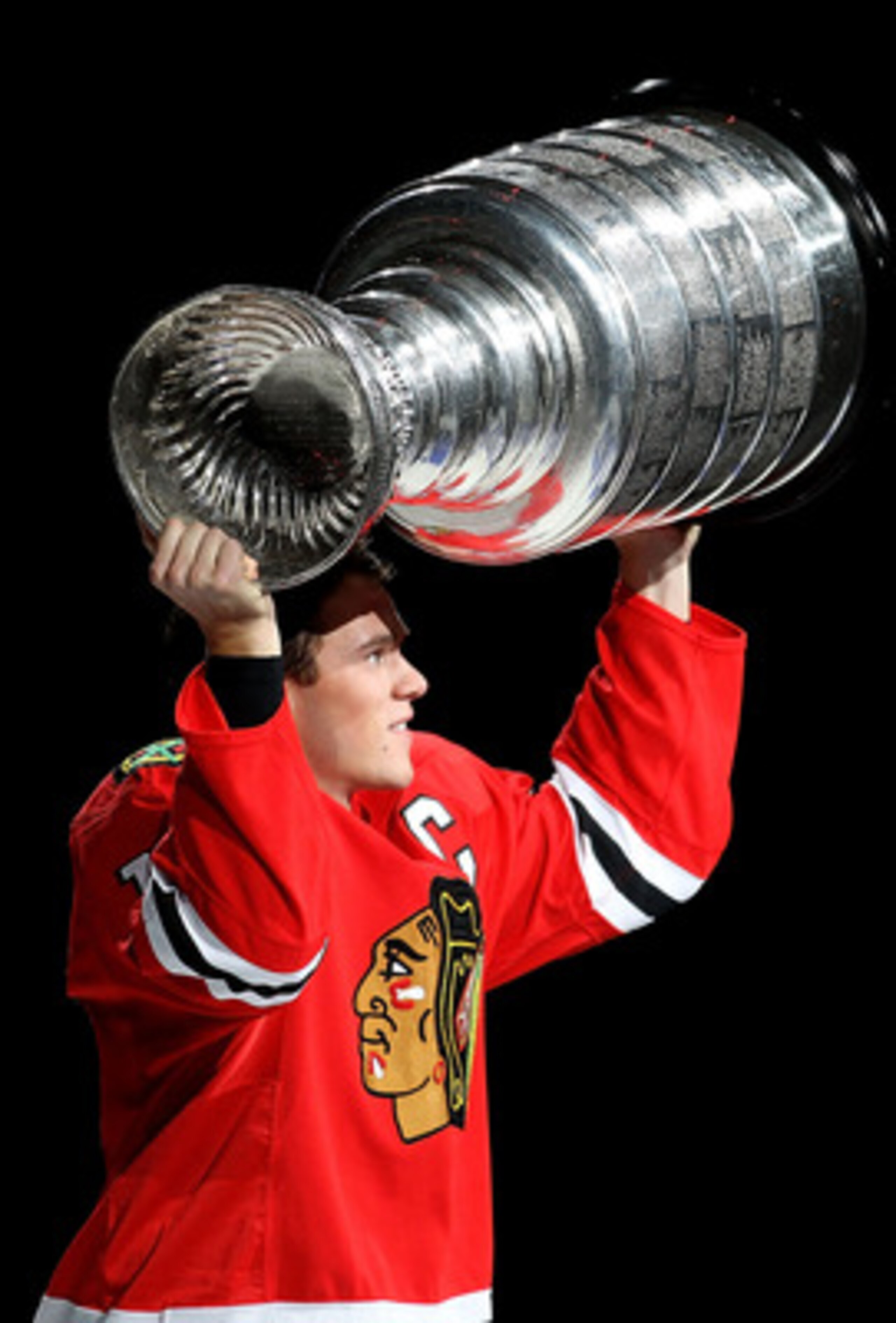 CHICAGO - OCTOBER 09: Jonathan Toews #19 of the Chicago Blackhawks carries the Stanley Cup trophy across the ice in a ceremony before the Blackhawks season home opening game against the Detroit Red Wings at the United Center on October 9, 2010 in Chicago,