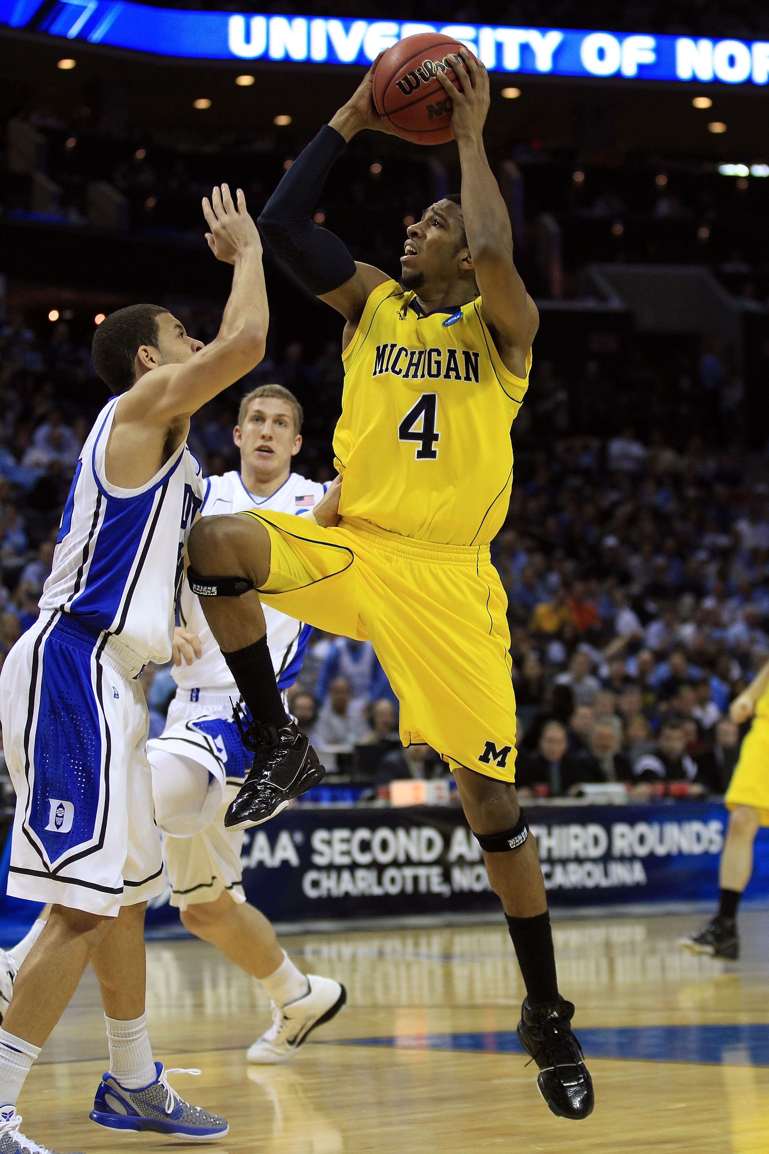 CHARLOTTE, NC - MARCH 20:  Darius Morris #4 of the Michigan Wolverines goes up for a shot against Seth Curry #30 of the Duke Blue Devils during the third round of the 2011 NCAA men's basketball tournament at Time Warner Cable Arena on March 20, 2011 in Ch