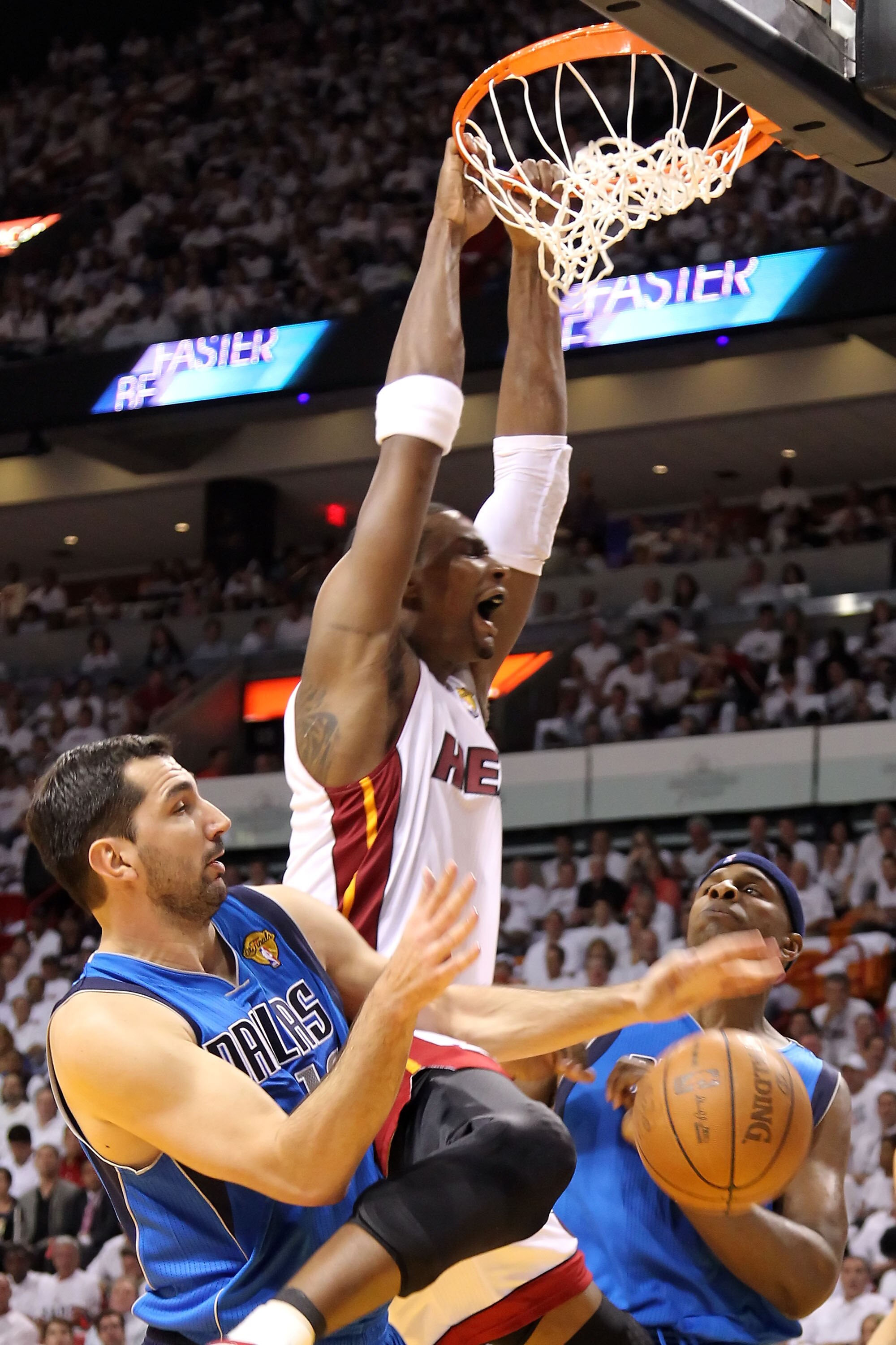 MIAMI, FL - MAY 31:  Chris Bosh #1 of the Miami Heat dunks the ball between Peja Stojakovic #16 and Brendan Haywood #33 of the Dallas Mavericks in the first half in Game One of the 2011 NBA Finals at American Airlines Arena on May 31, 2011 in Miami, Flori