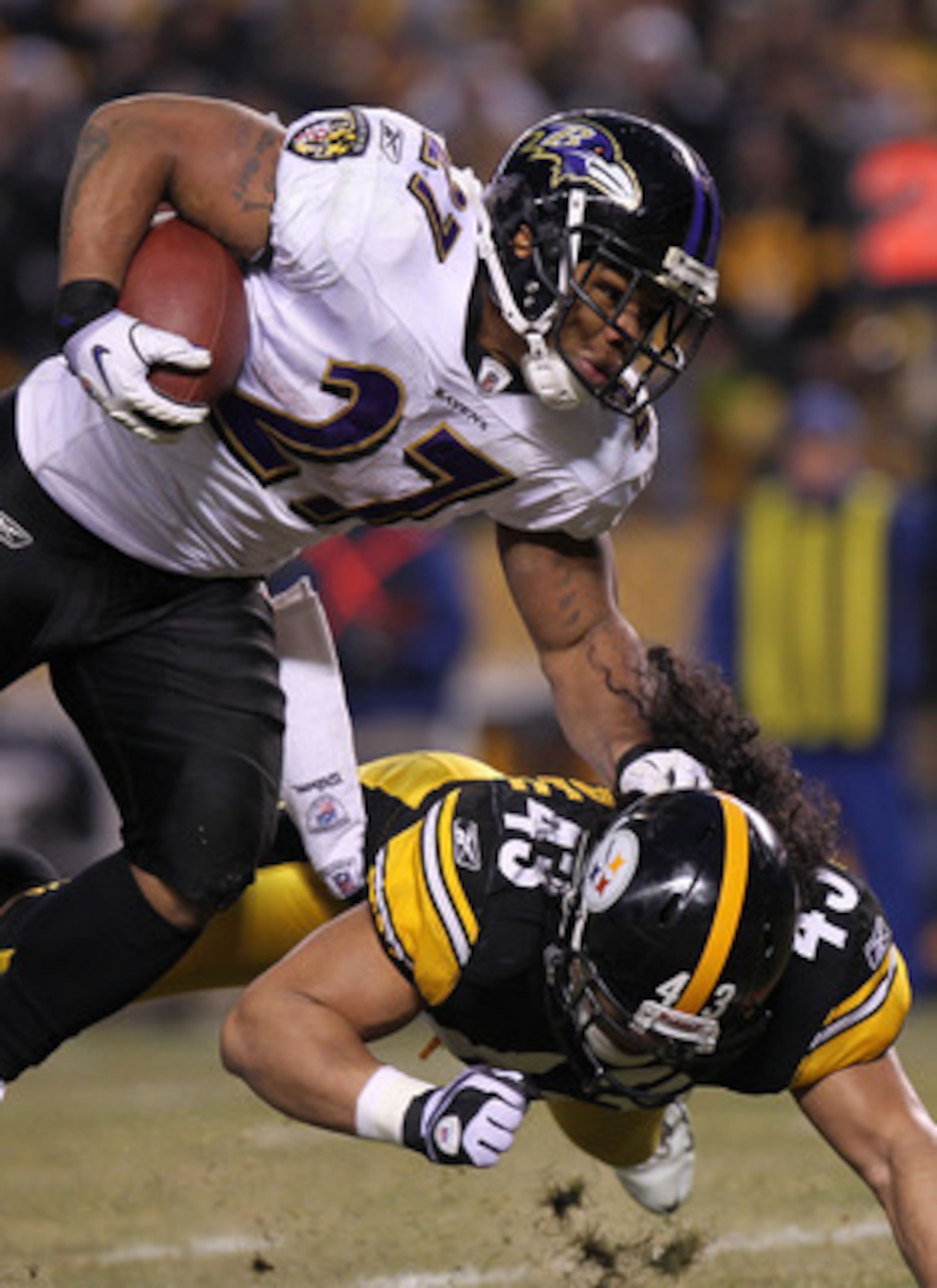 PITTSBURGH, PA - JANUARY 15:  Running back Ray Rice #27 of the Baltimore Ravens runs with the ball after being hit by safety Troy Polamalu #43 of the Pittsburgh Steelers in the AFC Divisional Playoff Game at Heinz Field on January 15, 2011 in Pittsburgh,