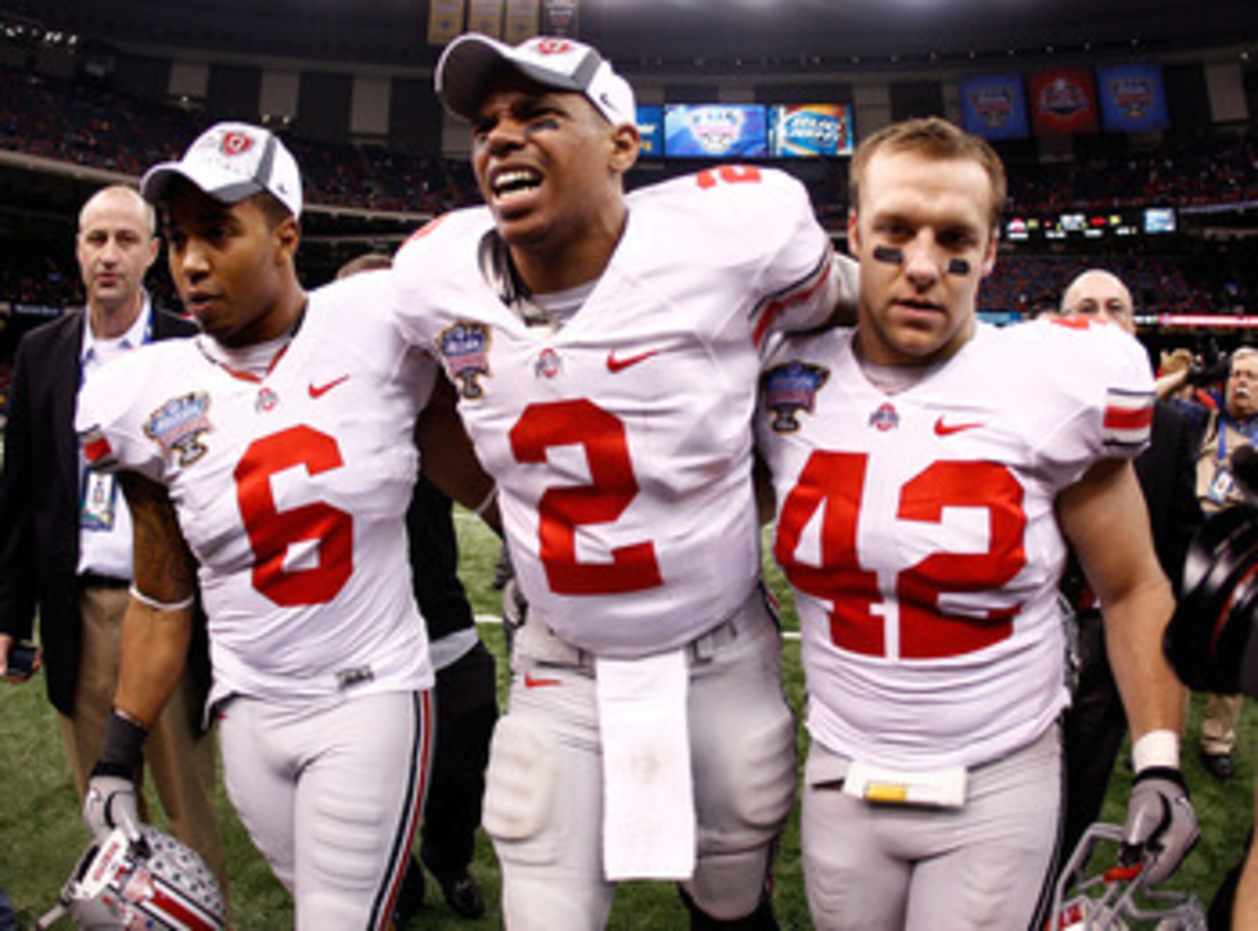 NEW ORLEANS, LA - JANUARY 04: (M) Quarterback Terrelle Pryor #2 of the Ohio State Buckeyes is helped off the field by teammates Etienne Sabino #6 and Andrew Sweat #42 after the Buckeyes 31-26 victory against the Arkansas Razorbacks during the Allstate Su NEW ORLEANS, LA - JANUARY 04: (M) Quarterback Terrelle Pryor #2 of the Ohio State Buckeyes is helped off the field by teammates Etienne Sabino #6 and Andrew Sweat #42 after the Buckeyes 31-26 victory against the Arkansas Razorbacks during the Allstate Su