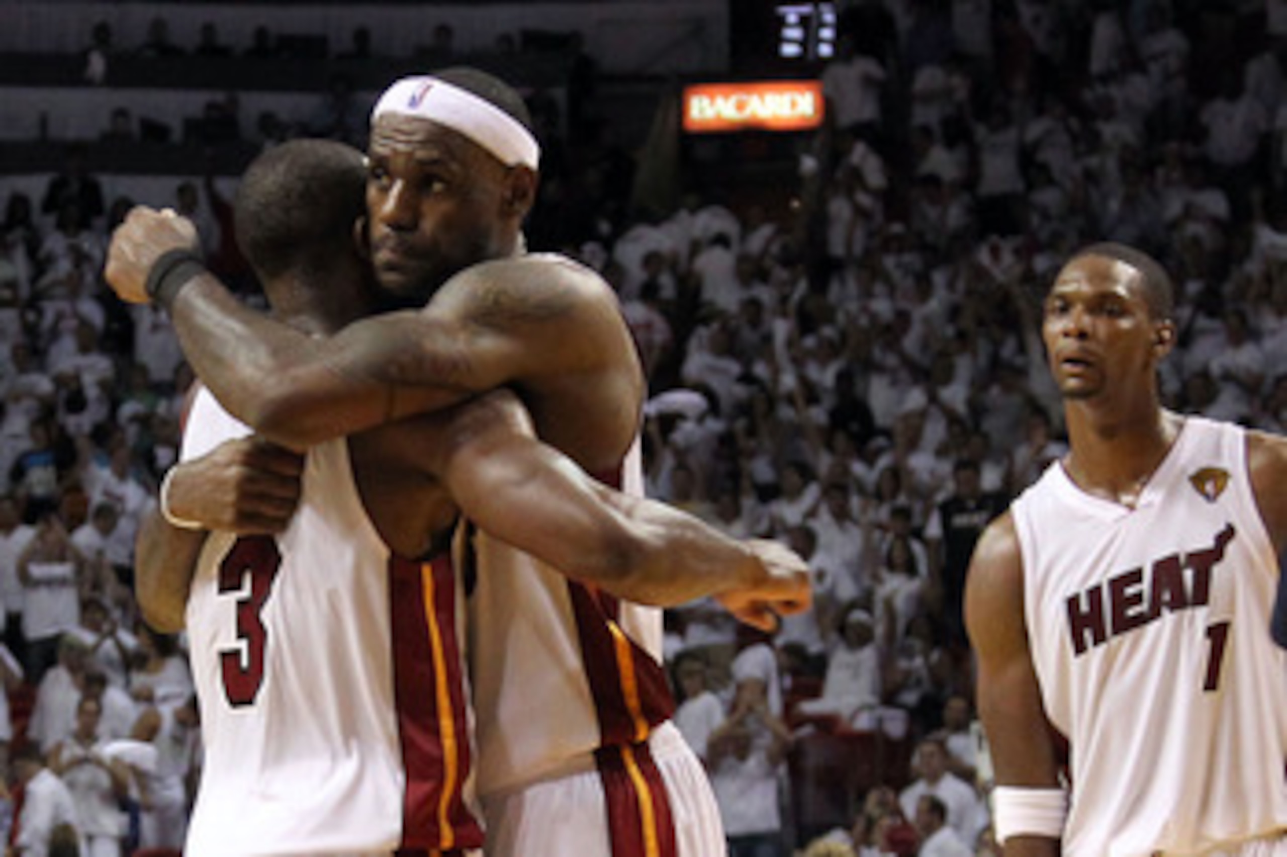 MIAMI, FL - MAY 31:  LeBron James #6 and Dwyane Wade #3 of the Miami Heat hug alongside teammate Chris Bosh #1 of the Miami Heat after the Heat defeat the Dallas Mavericks 92-84 in Game One of the 2011 NBA Finals at American Airlines Arena on May 31, 2011