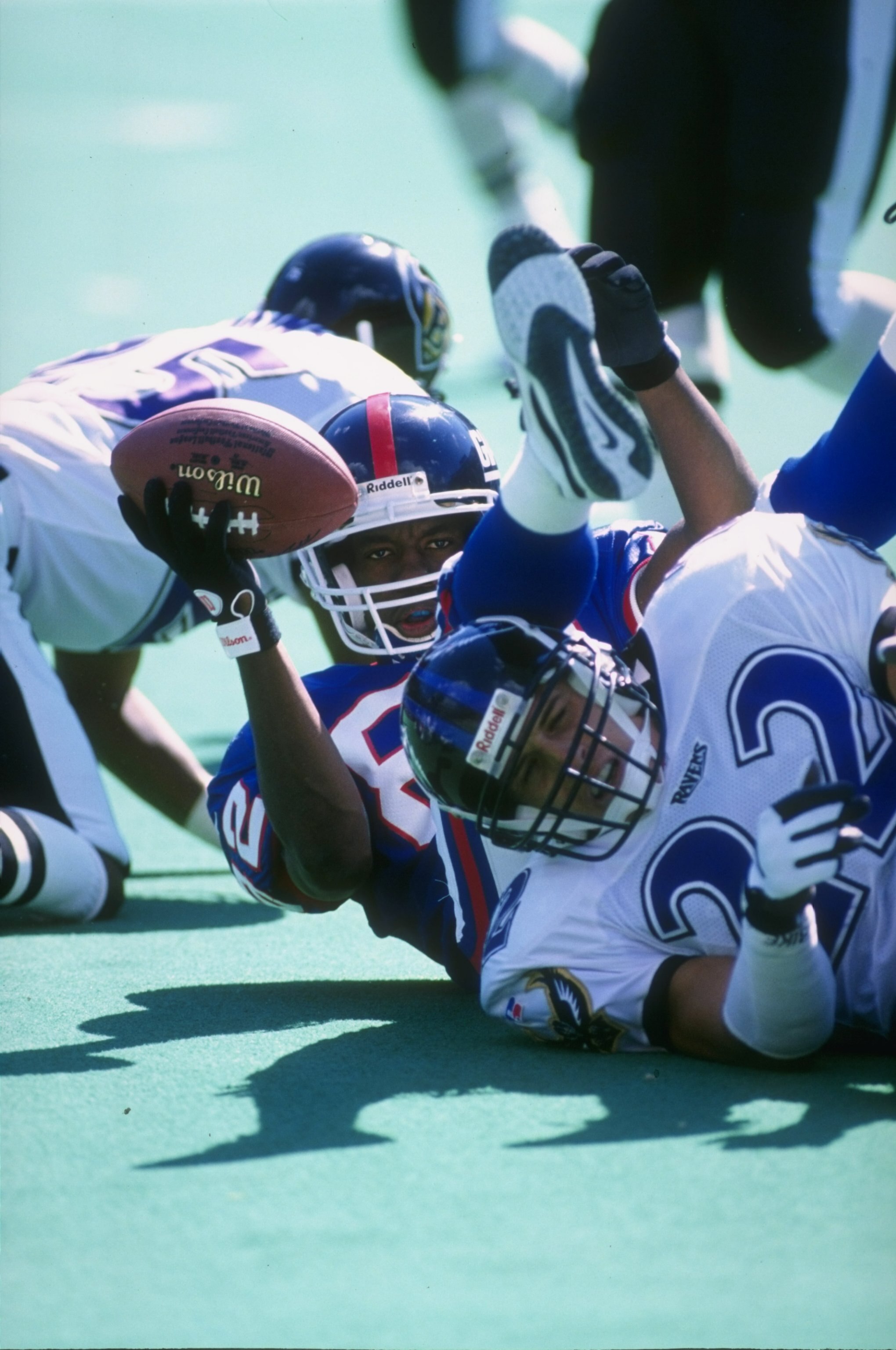 10 Aug 1996:  Wide receiver Omar Douglas #82 of the New York Giants hangs onto the ball after being tackled by defensive back Dante DePaola #22 of the Baltimore Ravens following a reception in the Giants 37-27 loss to the Ravens at Giant Stadium in East R
