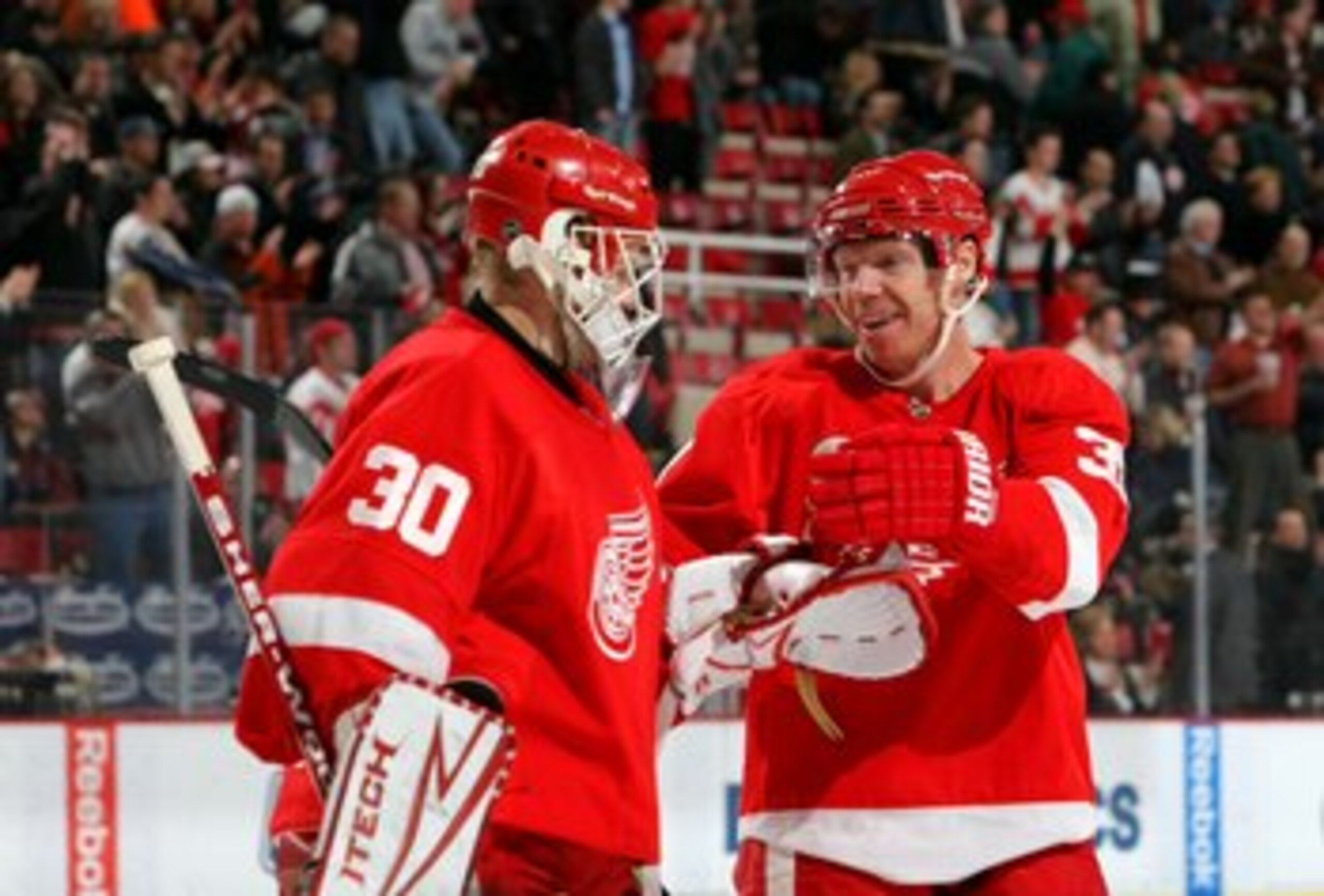 DETROIT - FEBRUARY 4: Goaltender Chris Osgood #30 and Kris Draper #33 of the Detroit Red Wings celebrate after the NHL game against the Phoenix Coyotes at Joe Louis Arena on February 4, 2009 in Detroit, Michigan. The Red Wings defeated the Coyotes 5-4. DETROIT - FEBRUARY 4: Goaltender Chris Osgood #30 and Kris Draper #33 of the Detroit Red Wings celebrate after the NHL game against the Phoenix Coyotes at Joe Louis Arena on February 4, 2009 in Detroit, Michigan. The Red Wings defeated the Coyotes 5-4.