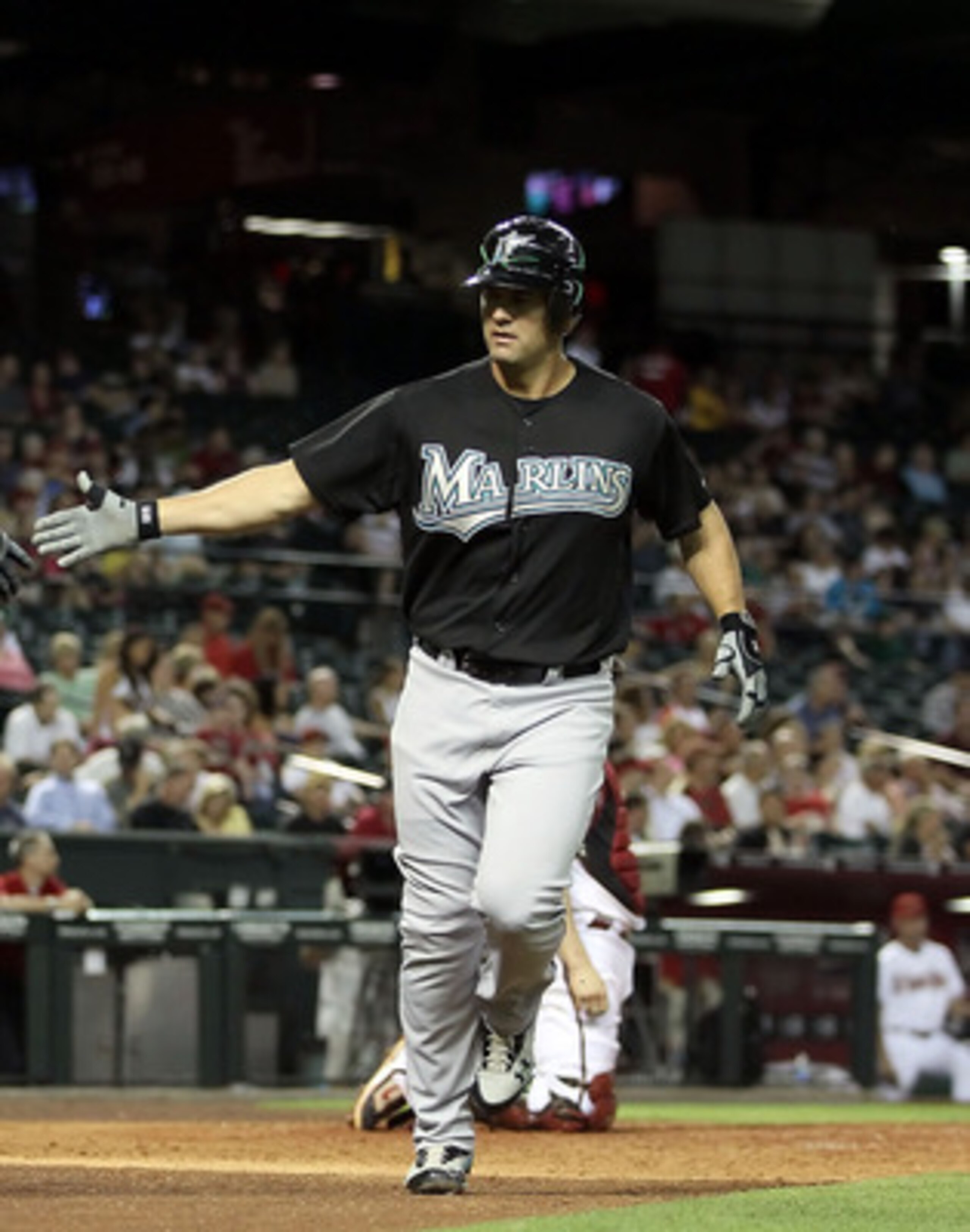 PHOENIX, AZ - MAY 31:  Gaby Sanchez #15 of the Florida Marlins high fives teammate Greg Dobbs #29 after Sanchez hit a solo home run against the Arizona Diamondbacks during the seventh inning of the Major League Baseball game at Chase Field on May 31, 2011