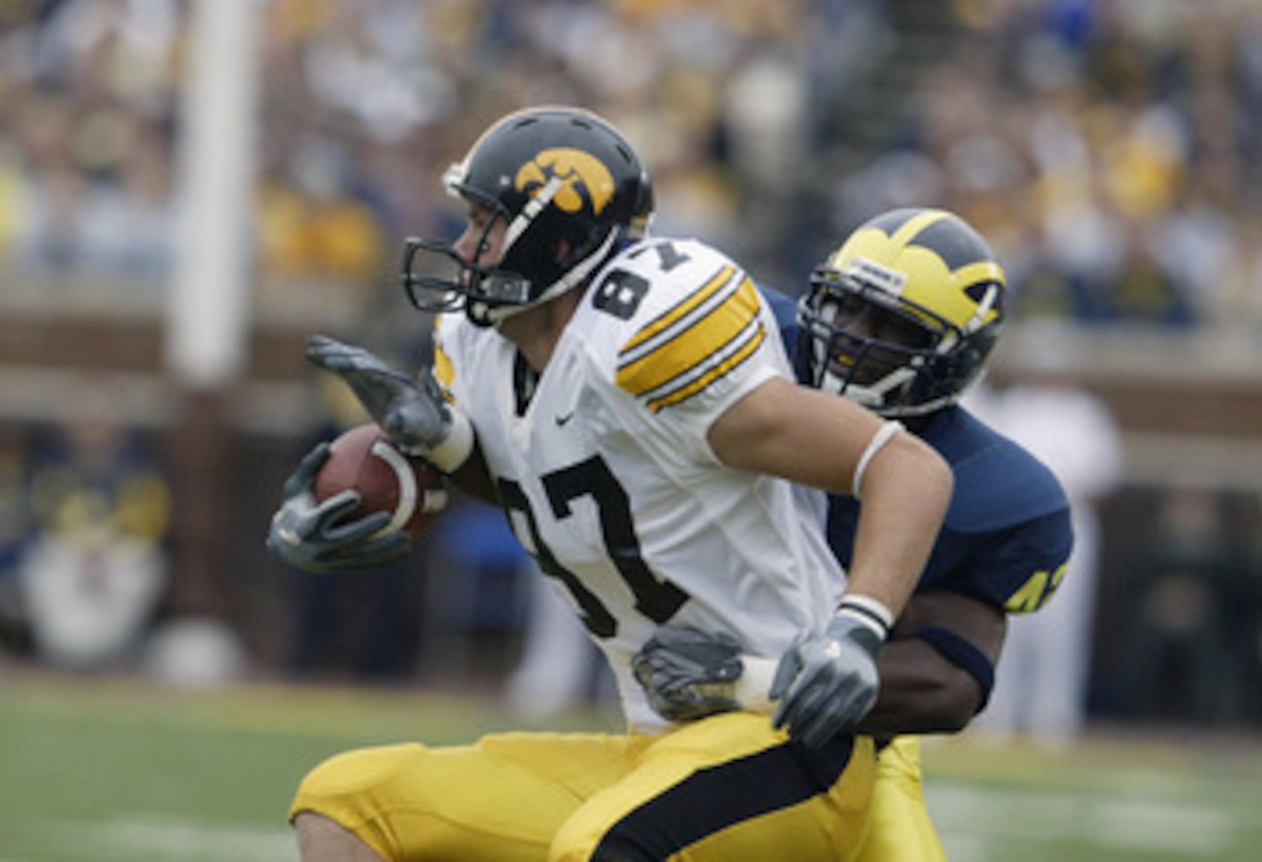 ANN ARBOR, MI - SEPTEMBER 25:  Scott Chandler #87 of the Iowa Hawkeyes runs after catching a short pass against Lawrence Reid #42 of the Michigan Wolverines during the game at Michigan Stadium on September 25, 2004 in Ann Arbor, Michigan.  Michigan defeat