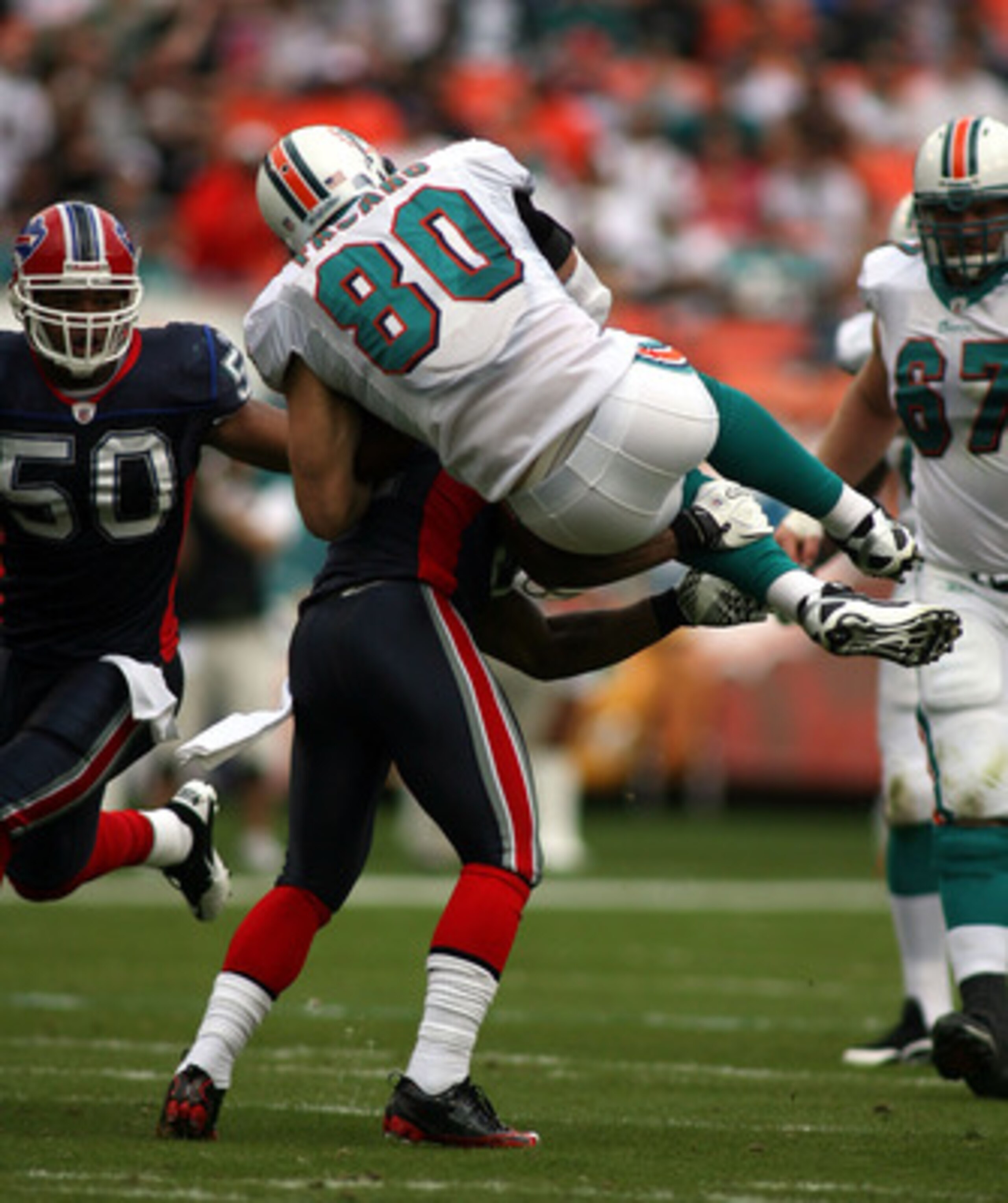 MIAMI - DECEMBER 19:  tight end Anthony Fasano #80 is upended by cornerback Donte Whitner #20 of the Buffalo Bills at Sun Life Stadium on December 19, 2010 in Miami, Florida.  (Photo by Marc Serota/Getty Images)