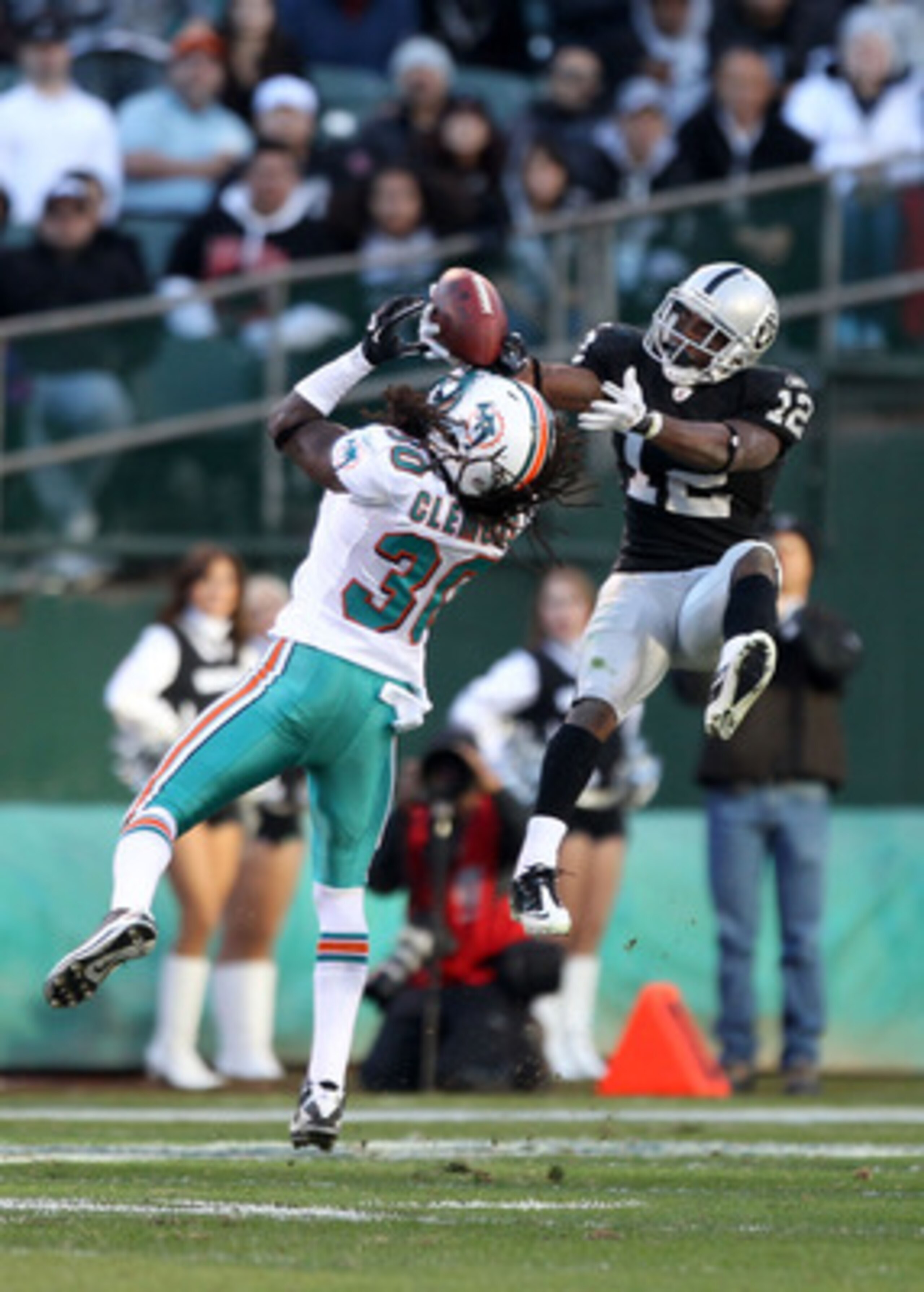 OAKLAND, CA - NOVEMBER 28:  Jacoby Ford #12 of the Oakland Raiders catches the ball while defended by Chris Clemons #30 of the Miami Dolphins at Oakland-Alameda County Coliseum on November 28, 2010 in Oakland, California.  (Photo by Ezra Shaw/Getty Images