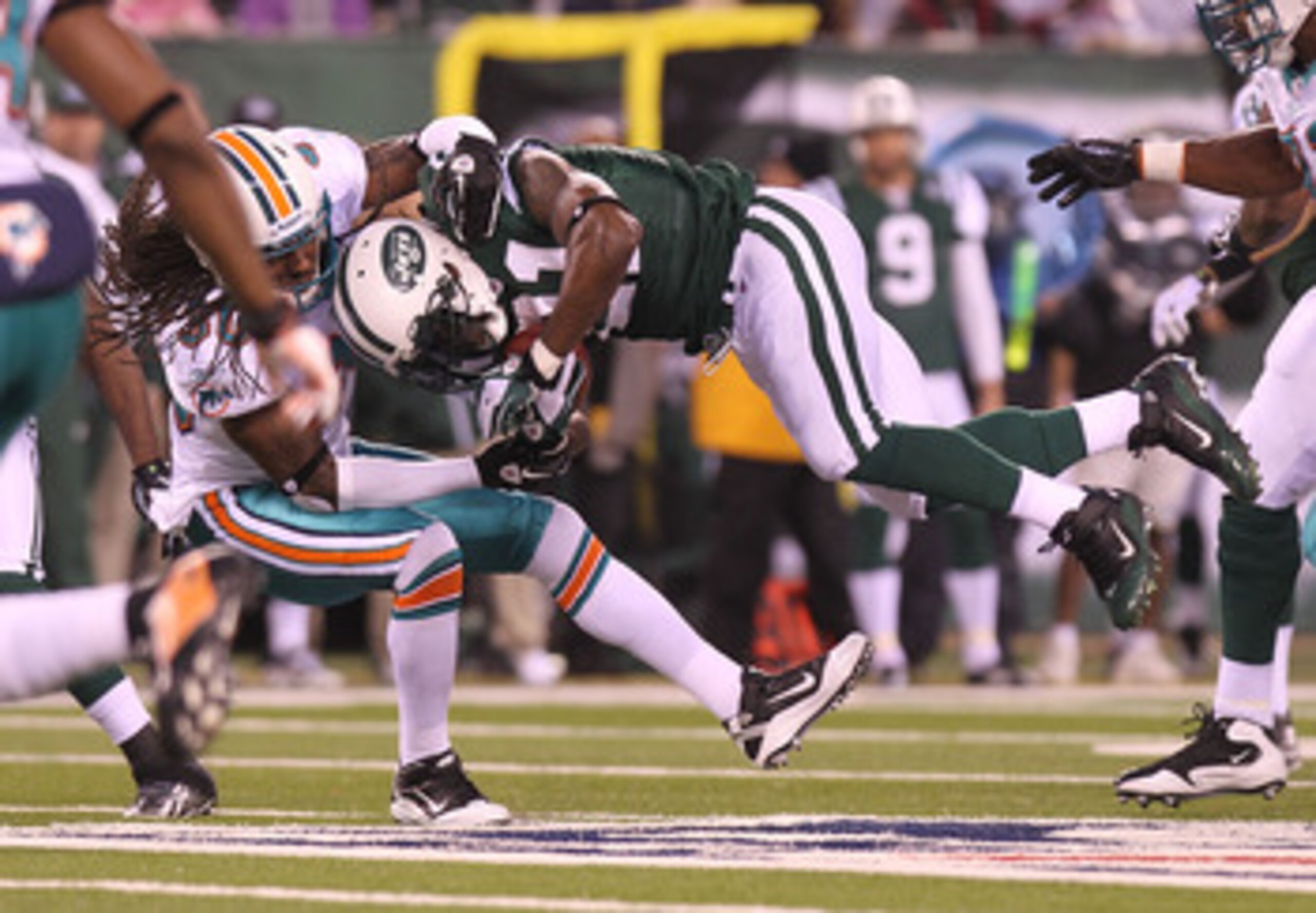 EAST RUTHERFORD, NJ - DECEMBER 12: LaDainian Tomlinson #21 of the New York Jets is tackled by Chris Clemons #30 of the Miami Dolphins at New Meadowlands Stadium on December 12, 2010 in East Rutherford, New Jersey.  (Photo by Nick Laham/Getty Images)