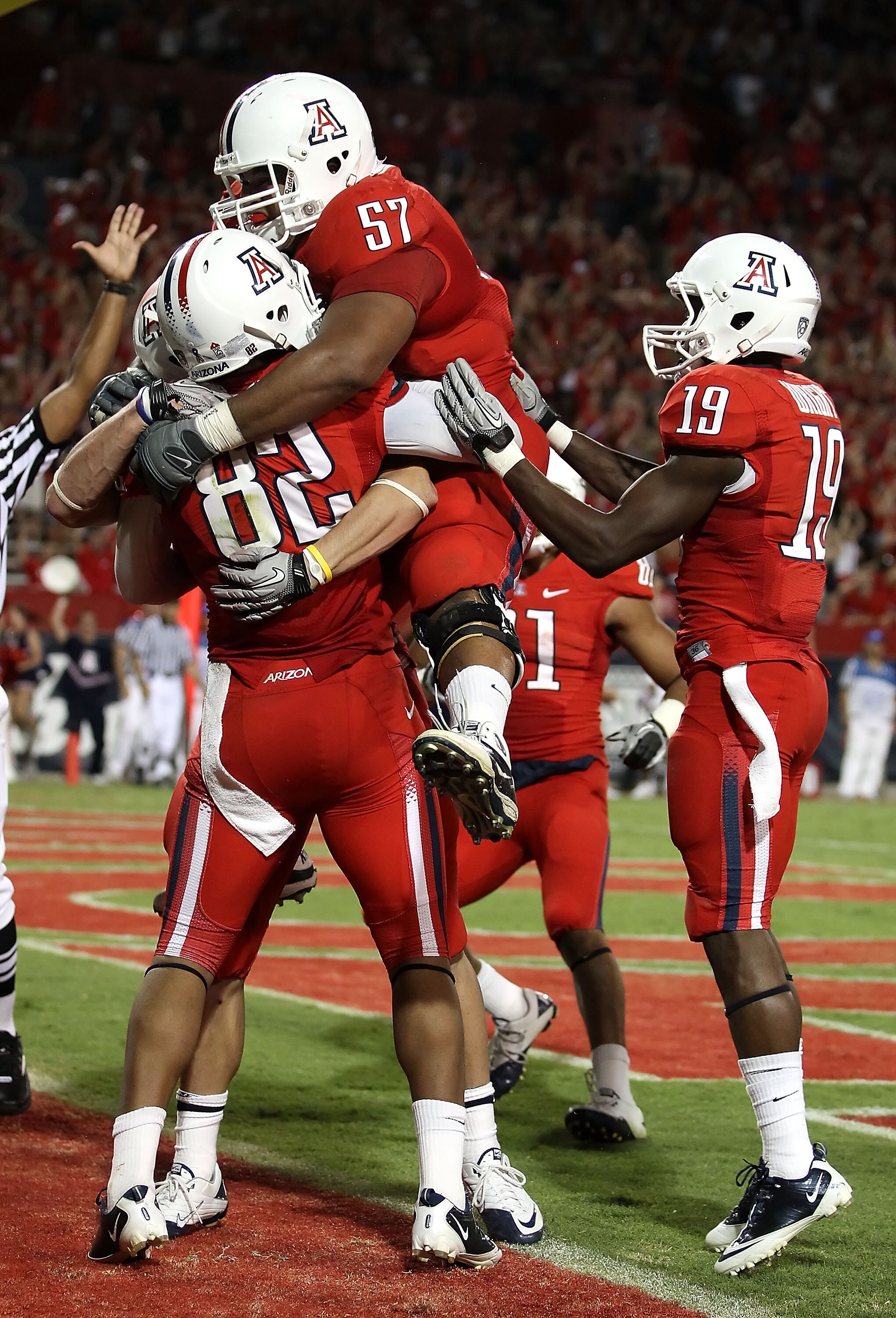 TUCSON, AZ - SEPTEMBER 25:  Jovon Hayes #57 of the Arizona Wildcats jumps into the arms of wide receiver Juron Criner #82 after Criner caught the game winning 3 yard touchdown reception against the California Bears during the fourth quarter of the college